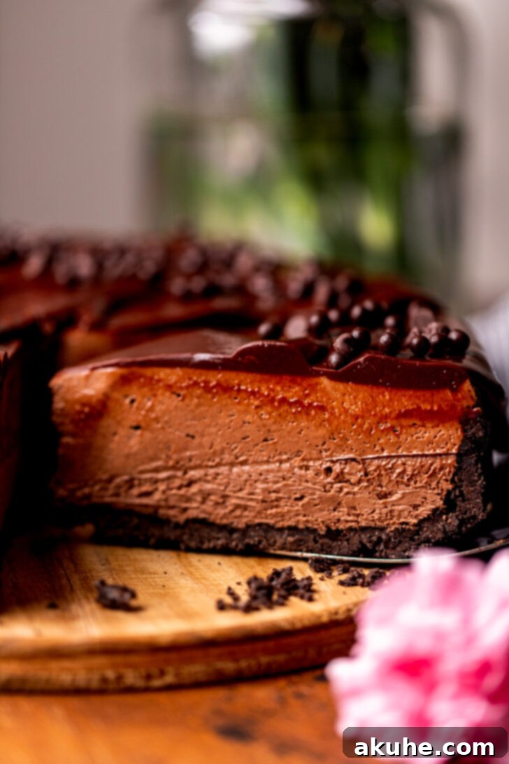 A serving of no-bake chocolate cheesecake being carefully removed from the main cake, showcasing its neat slice and creamy texture.