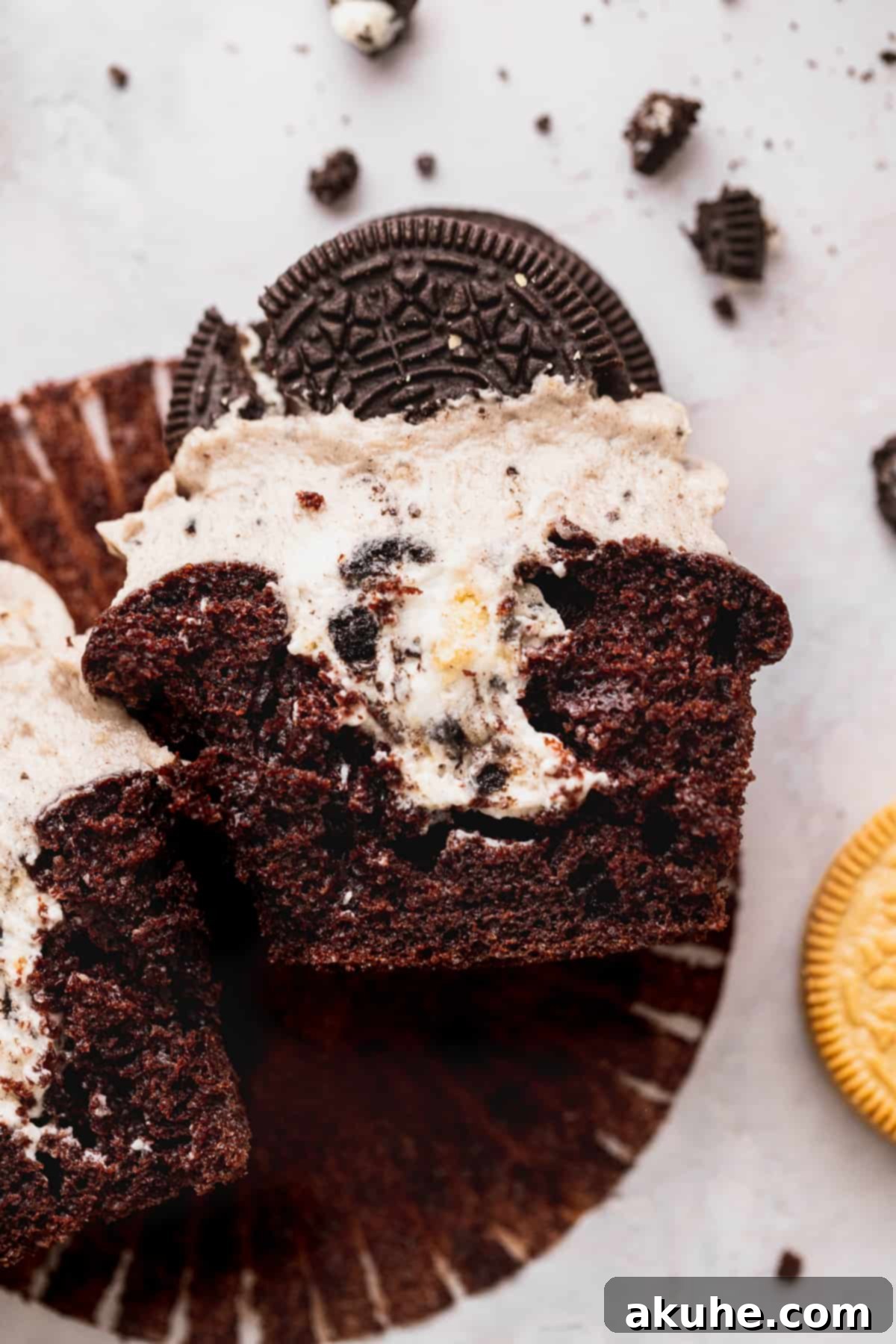 Decadent Oreo Cupcakes 3 A freshly baked Oreo cupcake cut in half, revealing the creamy whipped Oreo filling inside the moist chocolate cake.