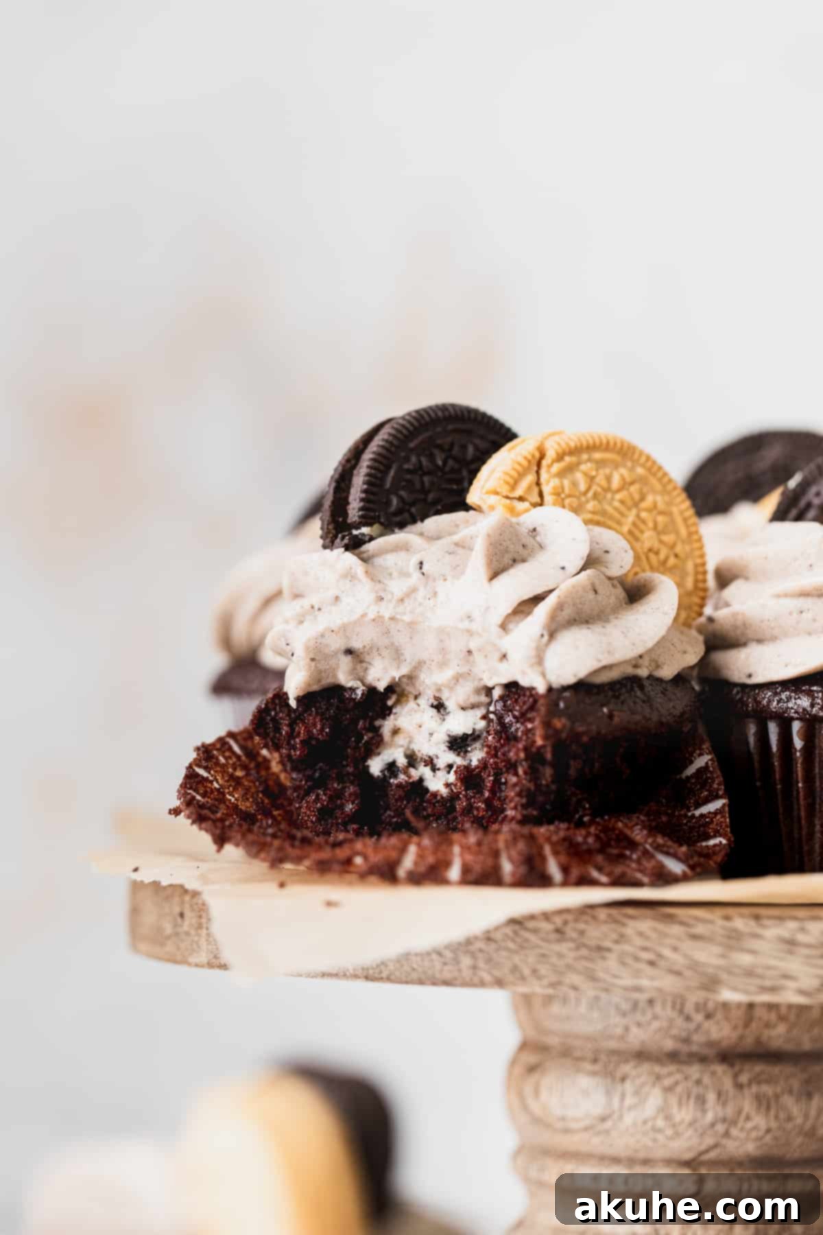 Decadent Oreo Cupcakes 4 Close-up of an Oreo cupcake with a bite taken out, showing the layers of cake, filling, and frosting, highlighting its deliciousness.