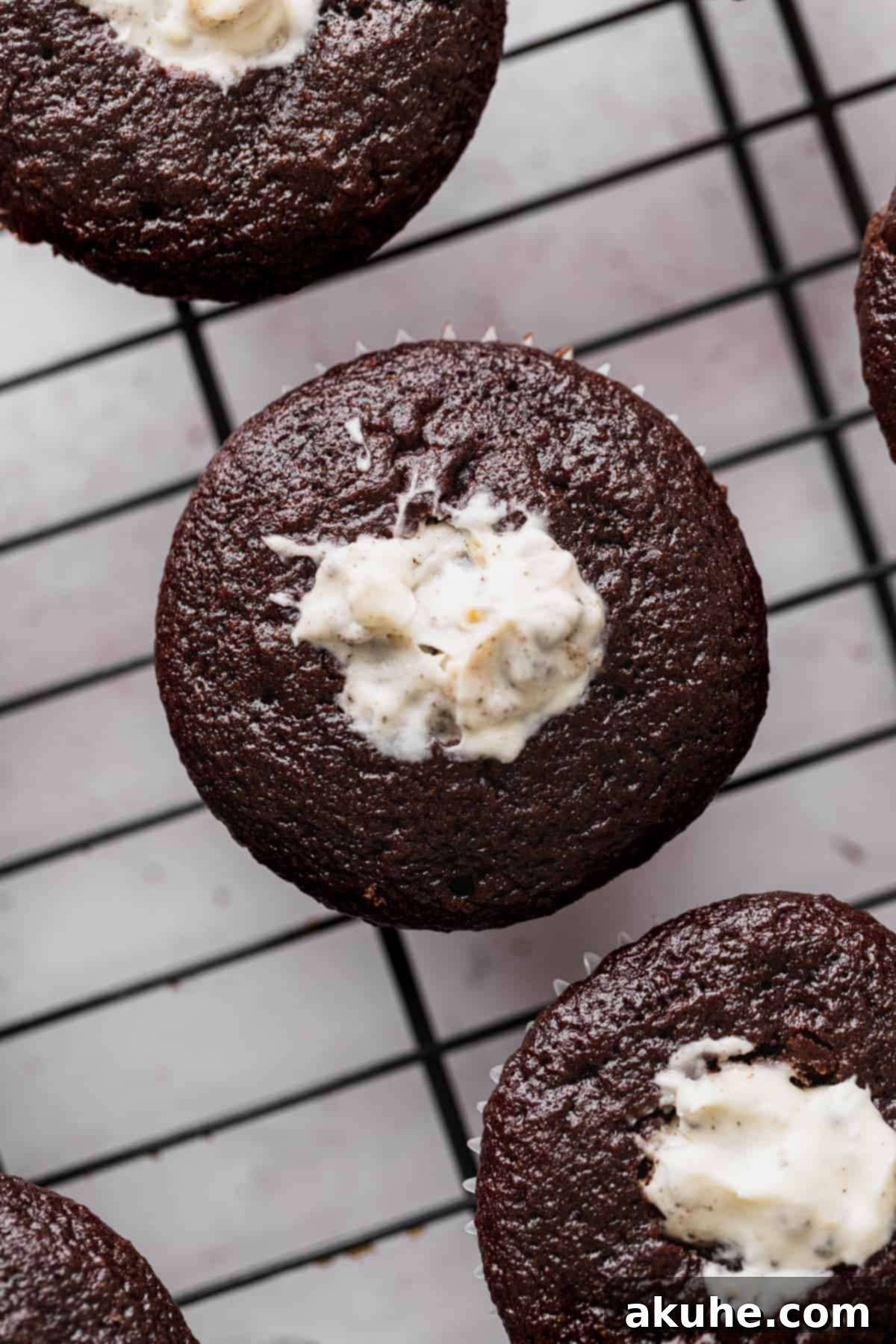 Decadent Oreo Cupcakes 8 Moist chocolate cupcakes on a wire rack, expertly cored and filled with creamy Oreo goodness.