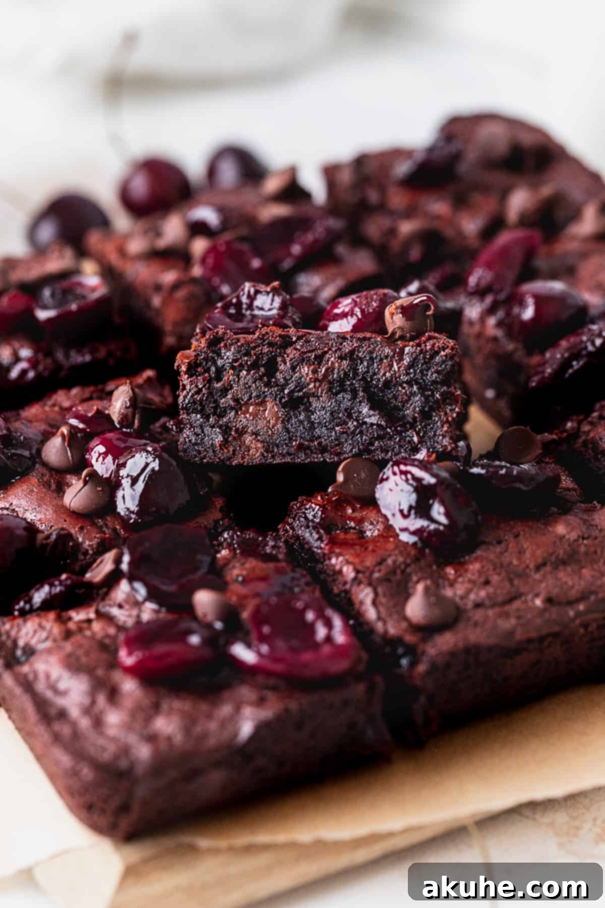 Deep-Roasted Cherry Chocolate Brownies 4 Close-up of fudgy roasted cherry brownies with a crinkle top, cut to show the texture.