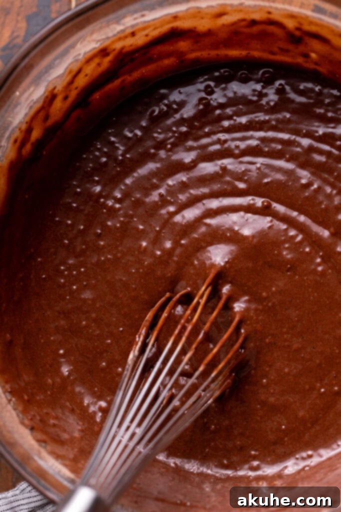 Decadent Butterfinger Crunch Cake 4 Chocolate cake batter in a glass bowl, perfectly smooth and ready for baking, showing no lumps.