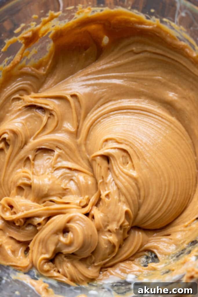 Decadent Butterfinger Crunch Cake 7 Creamy peanut butter filling in a glass bowl, smooth and ready to be piped into the cake.