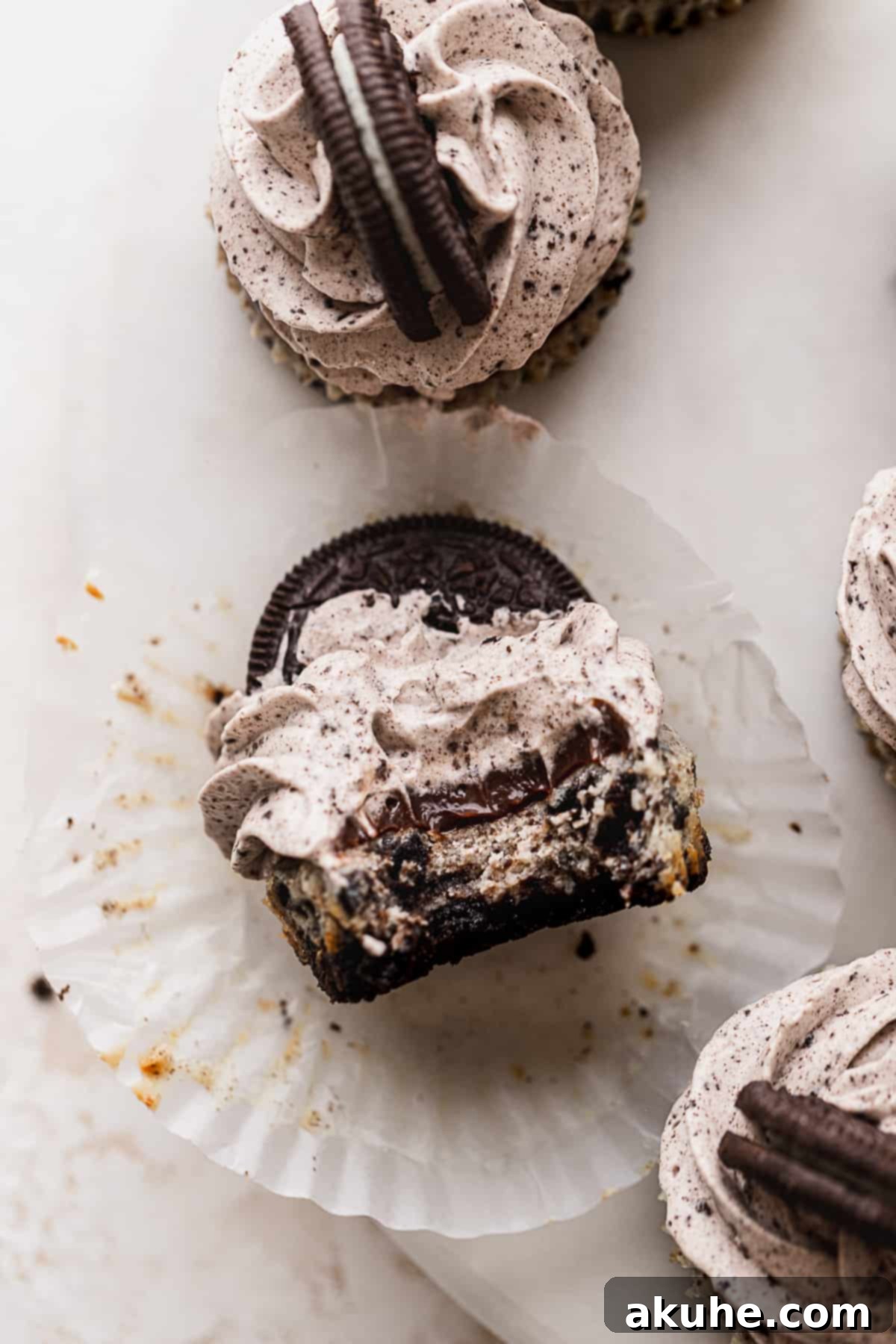 Bite-Sized Oreo Cheesecakes 2 A bite missing from mini Oreo cheesecakes, revealing the creamy texture and Oreo pieces.