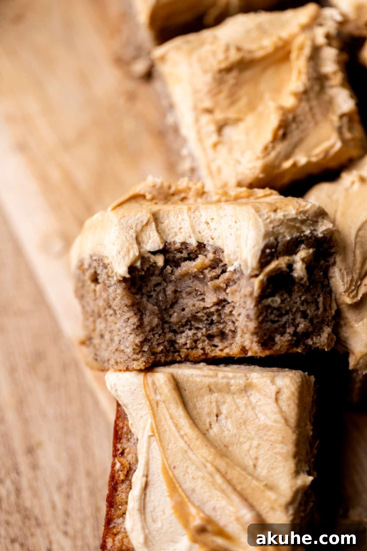 One-Bowl Banana Cake 2 A slice of moist banana snack cake with peanut butter frosting, with a bite taken out, showing its soft texture.
