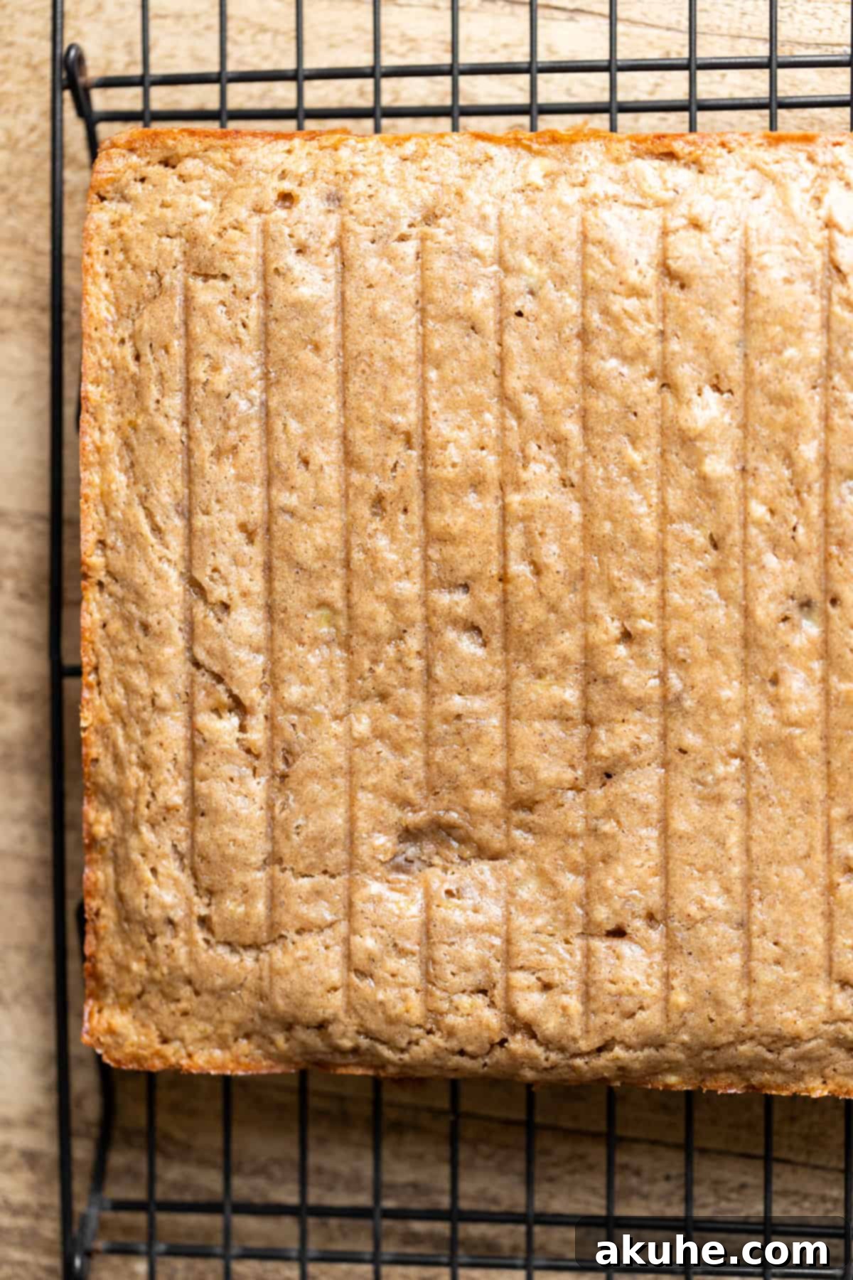 One-Bowl Banana Cake 6 Freshly baked banana cake resting on a wire rack, cooling down.