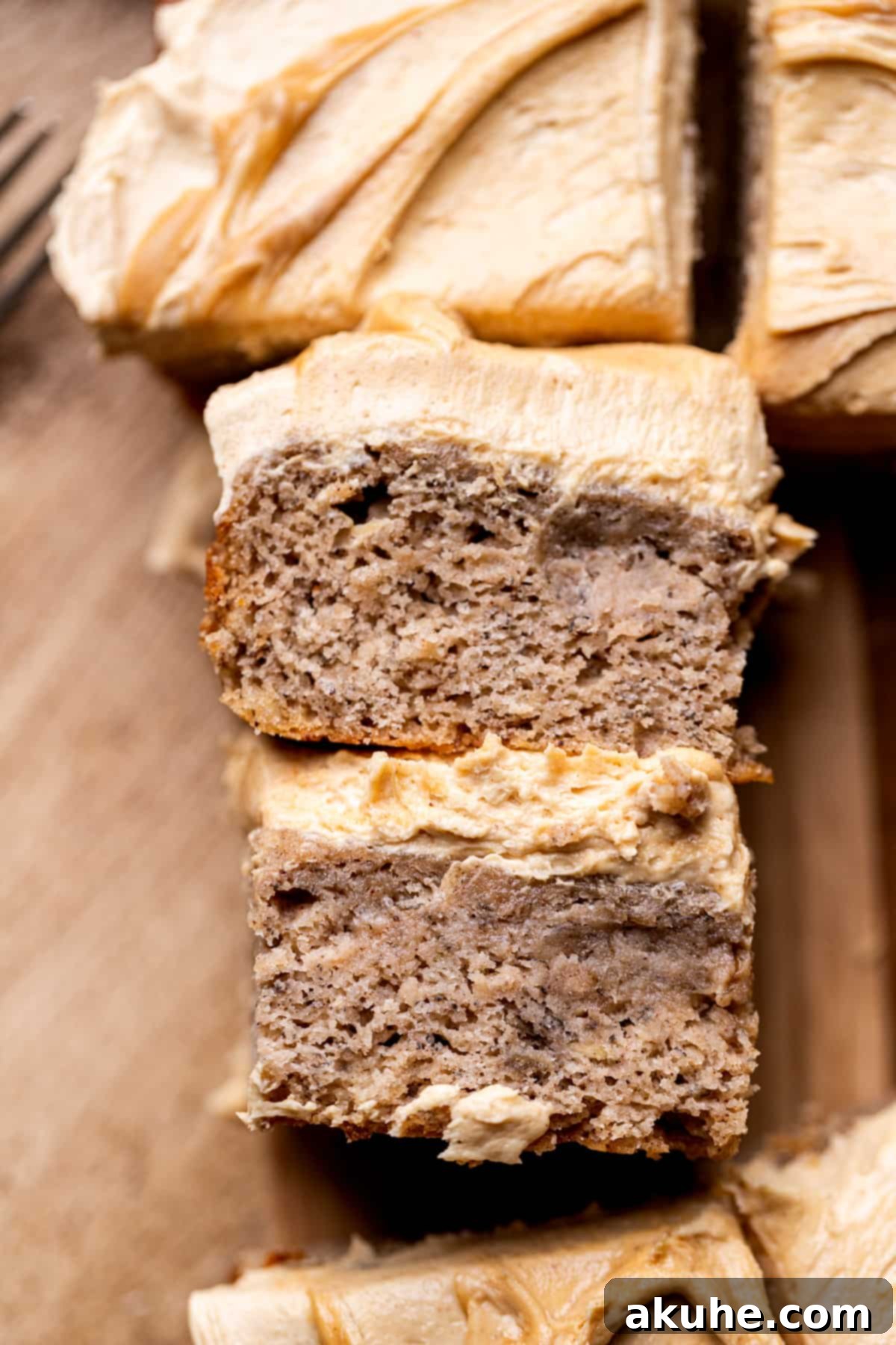 One-Bowl Banana Cake 9 Top view of two perfectly cut banana snack cake pieces on a serving plate.