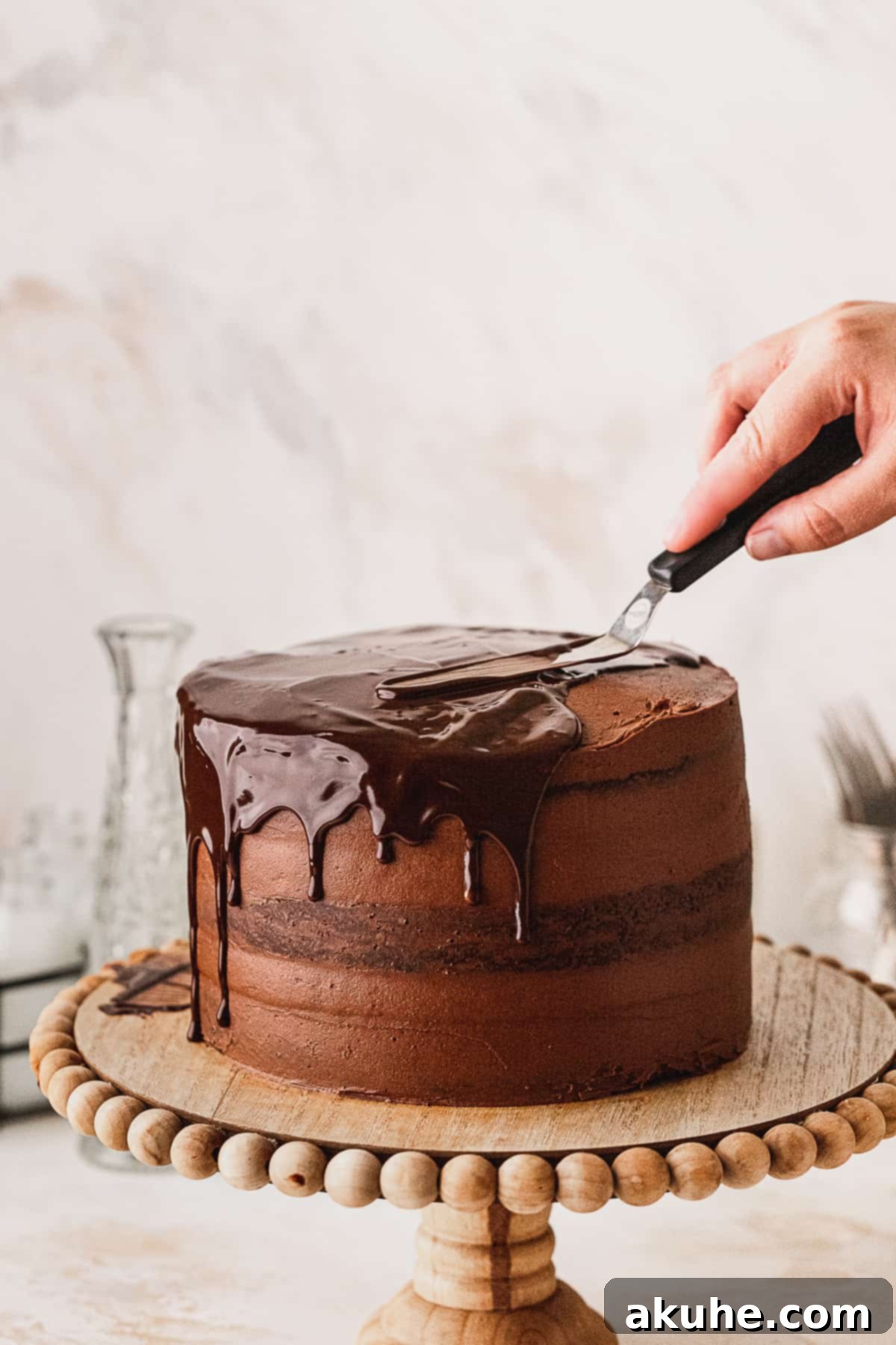 Decadent Cookie Brownie Cake 13 Drizzling chocolate ganache for a drip effect on top of a frosted cake.