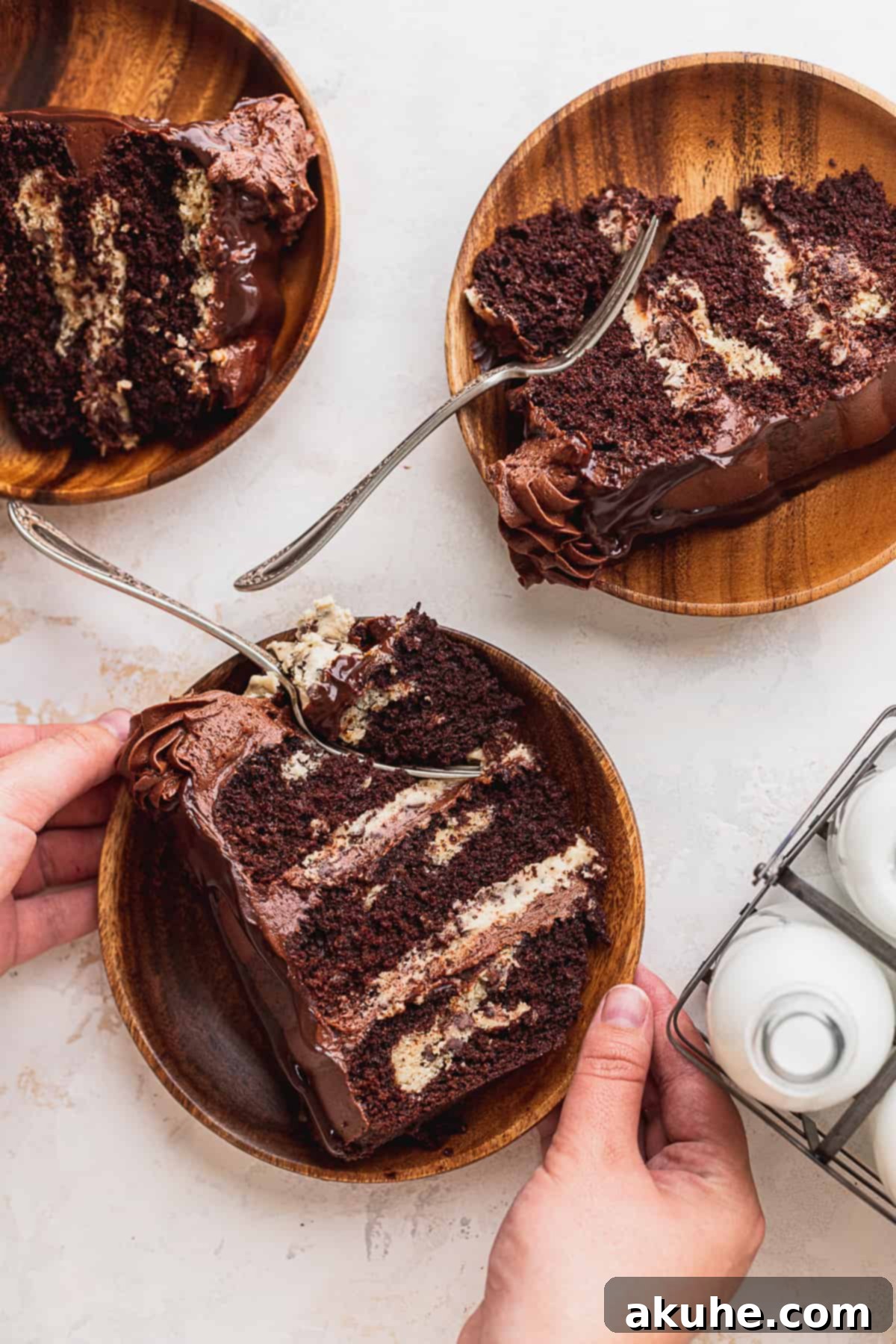 Decadent Cookie Brownie Cake 15 A hand gently removing a slice of chocolate cookie brownie cake from the full cake.