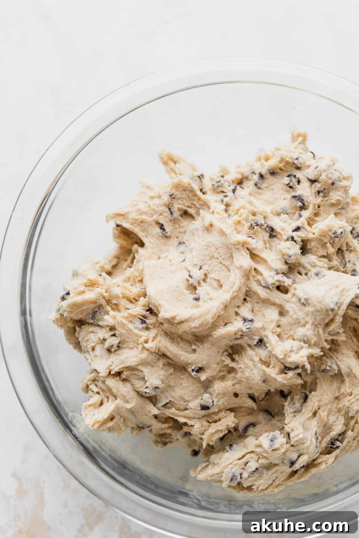 Decadent Cookie Brownie Cake 5 Cookie dough mixture in a clear glass bowl.