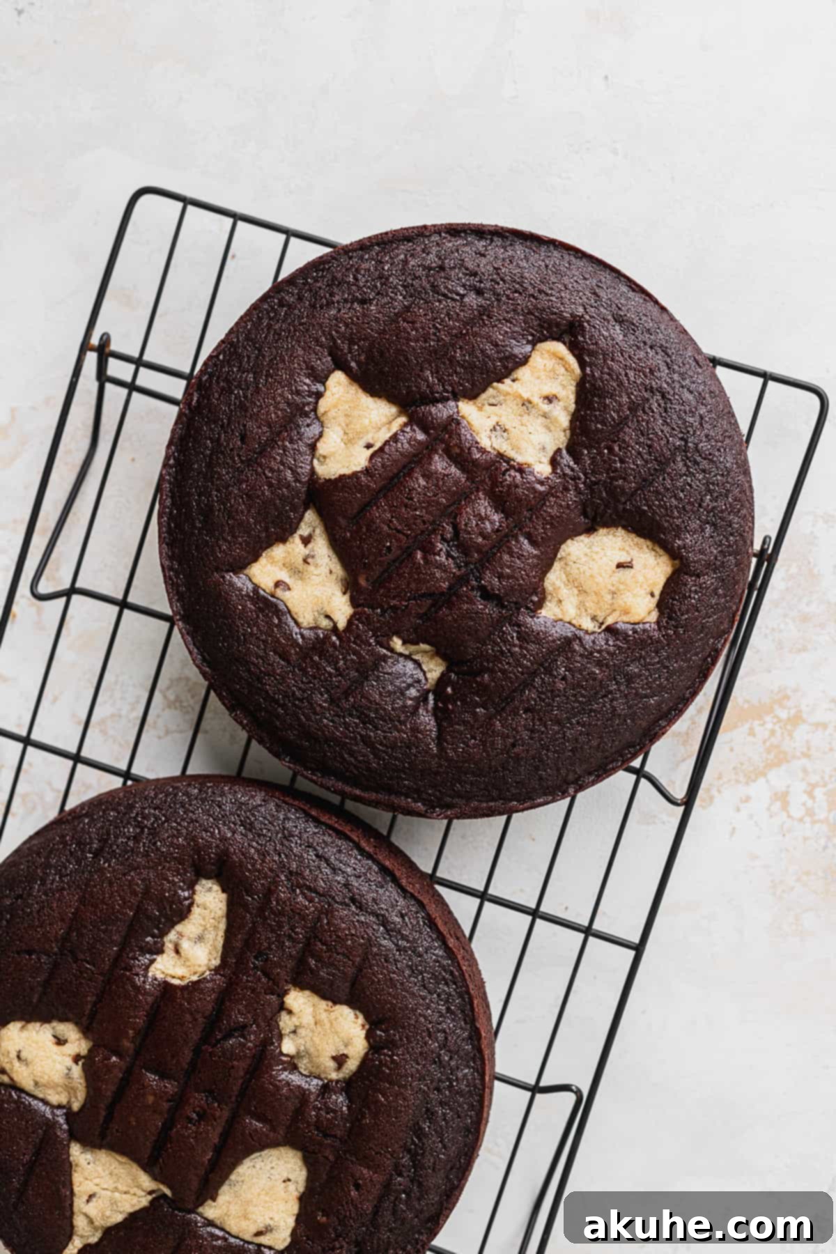 Decadent Cookie Brownie Cake 10 Baked chocolate cake layers cooling on a wire rack.