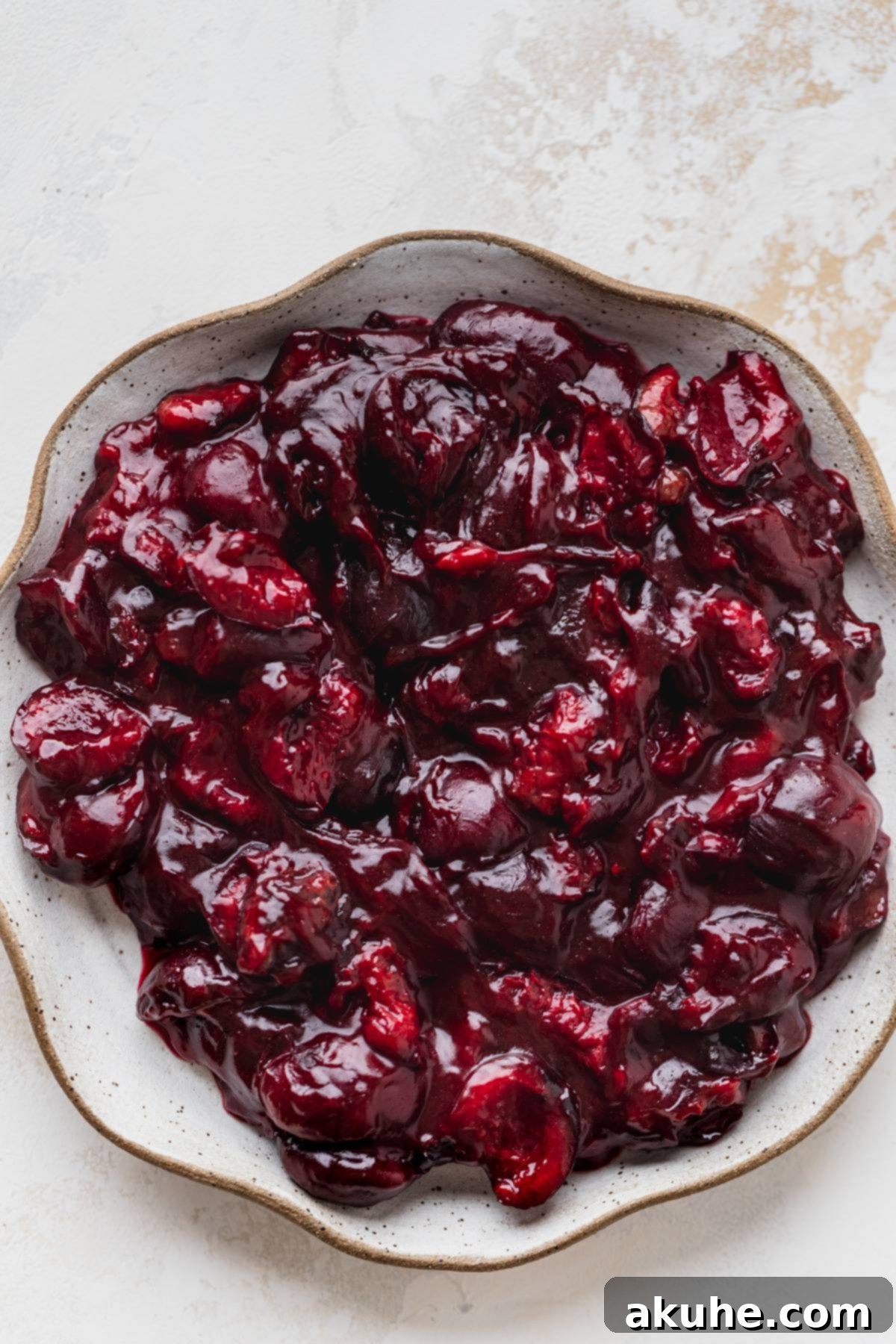 Decadent Black Forest Cupcakes 6 A serving of rich cherry pie filling on a white plate, showcasing its luscious texture and vibrant color.