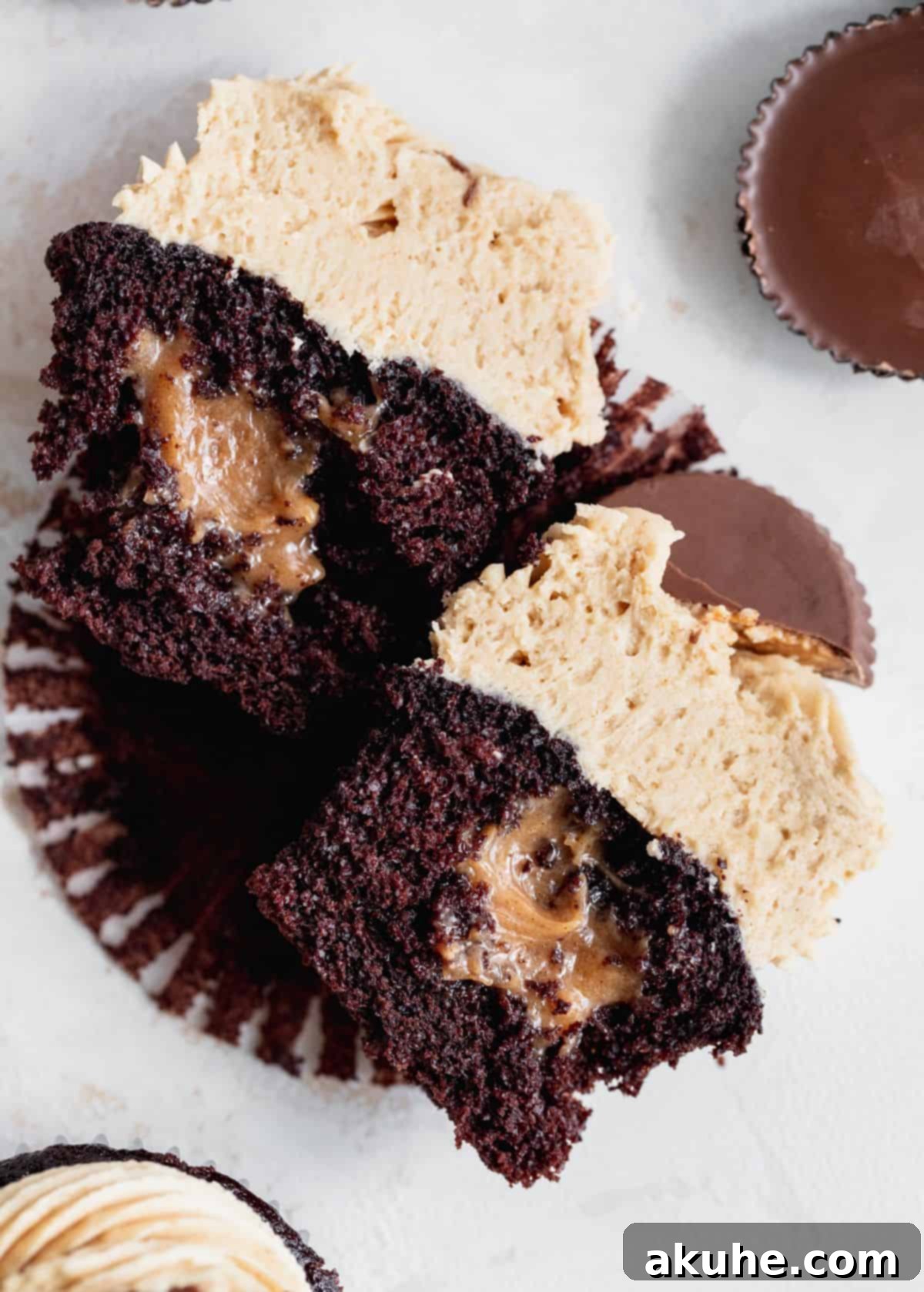 Peanut butter chocolate cupcakes split in half to see filling.