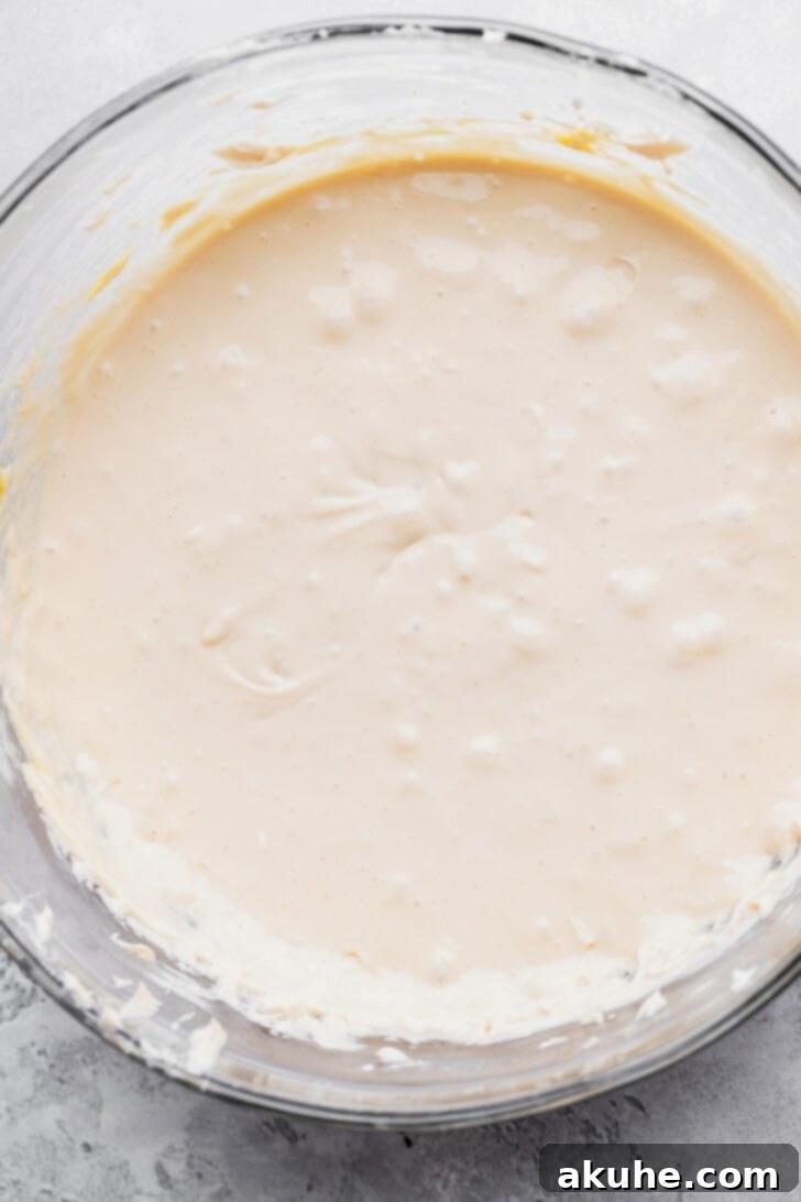 Smooth, creamy brown sugar cheesecake batter in a large mixing bowl, ready to be divided and swirled.