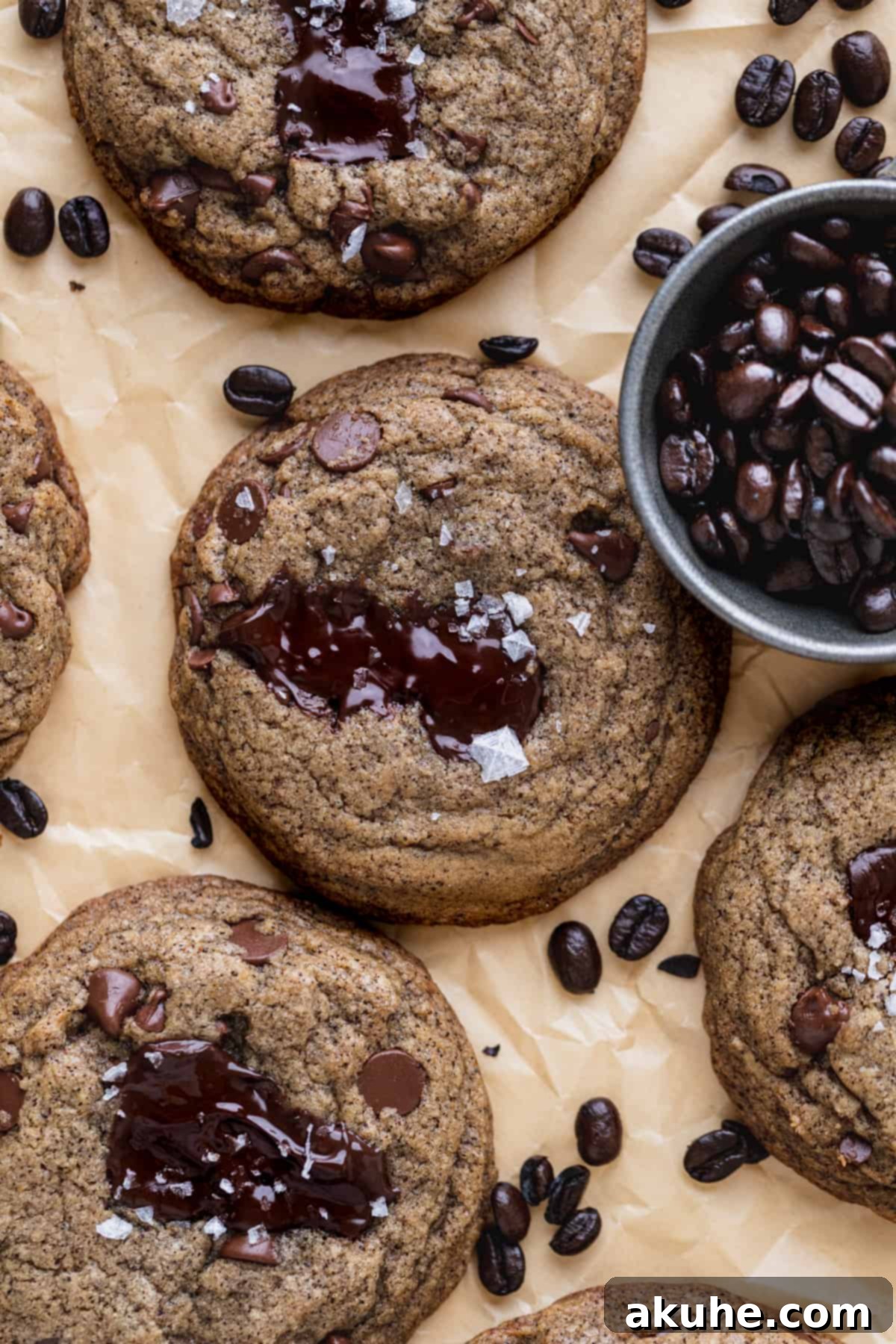 Freshly baked espresso chocolate chip cookies on parchment paper, ready to be enjoyed.