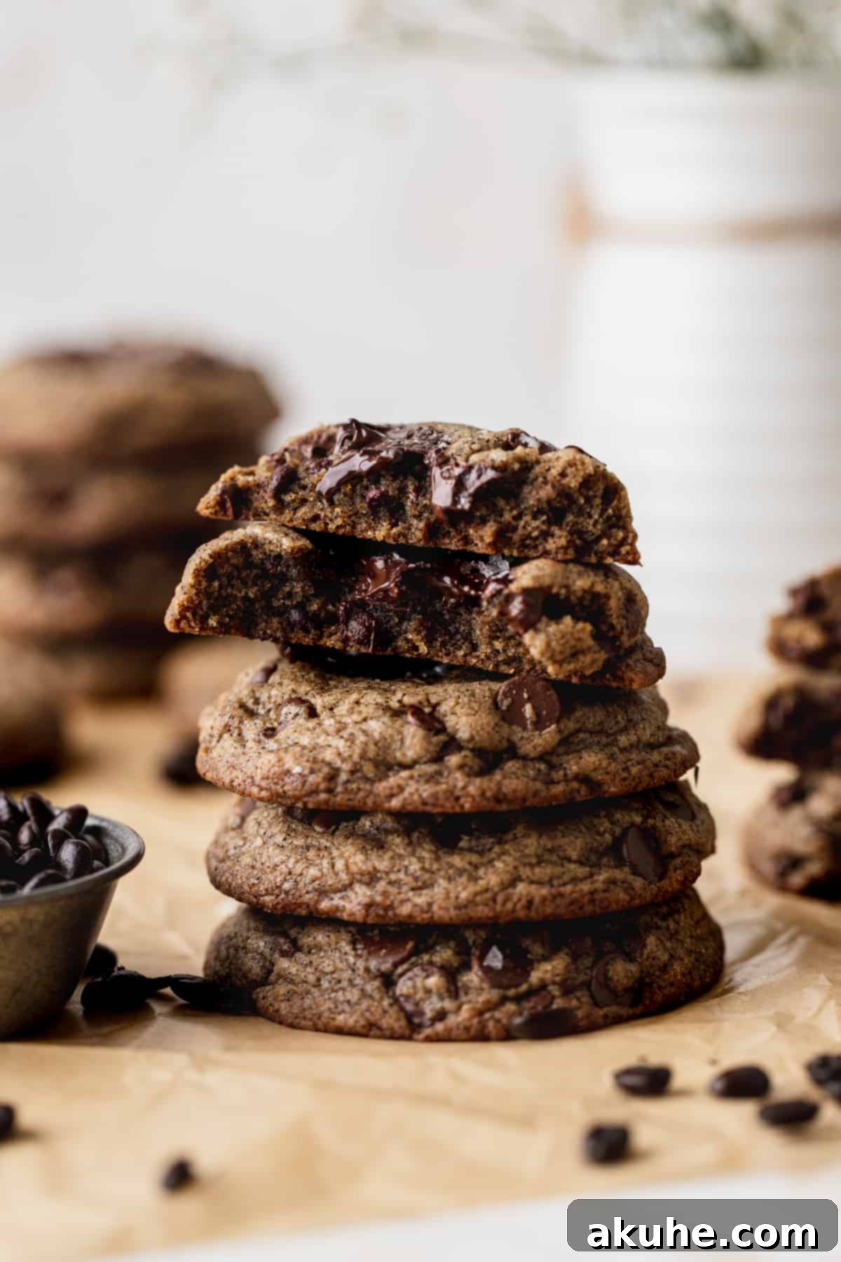 A stack of golden-brown espresso chocolate chip cookies, one cut in half to show its soft, chewy interior filled with melted chocolate.