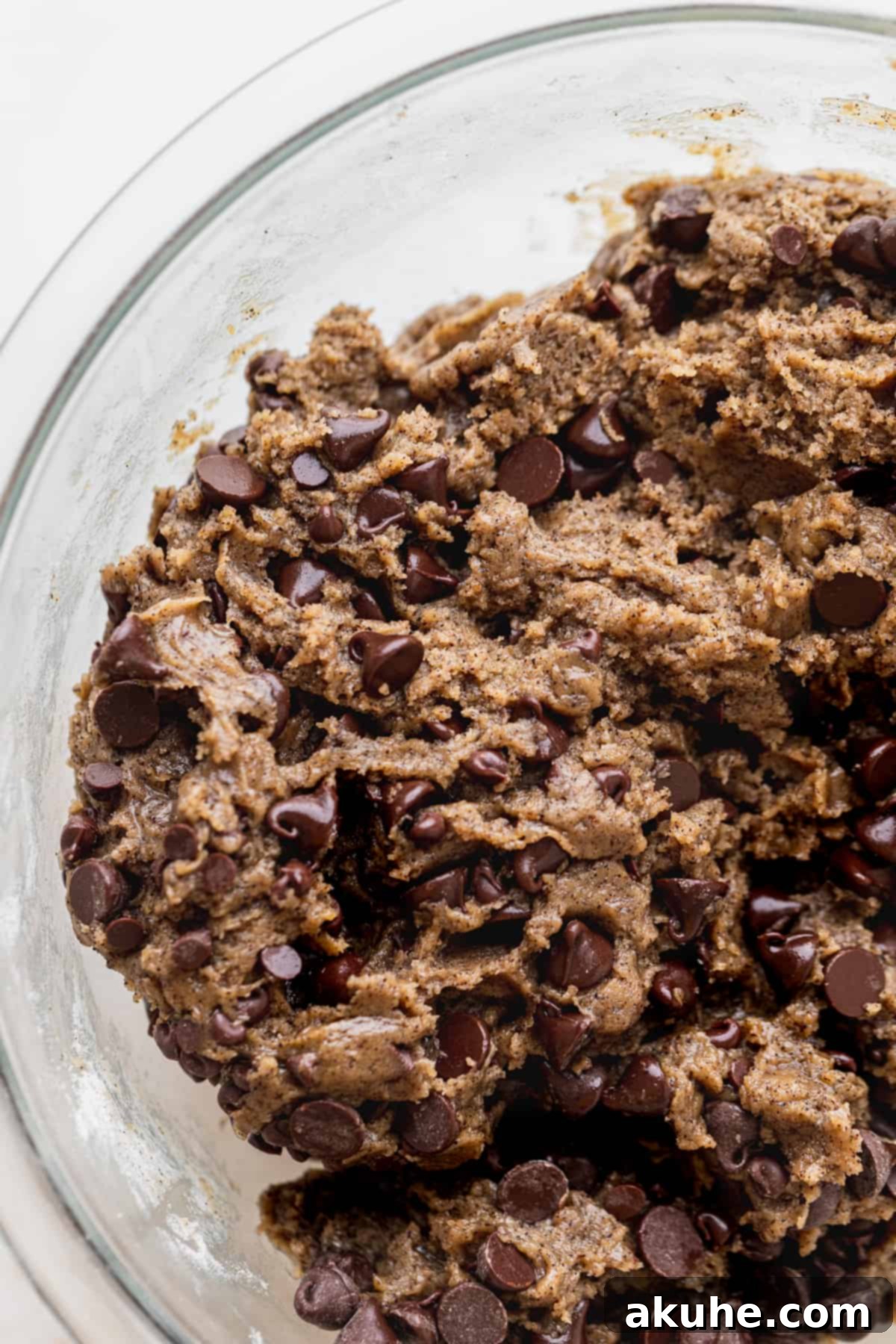 Another view of the rich, chocolate chip cookie dough in a glass bowl, ready for scooping.