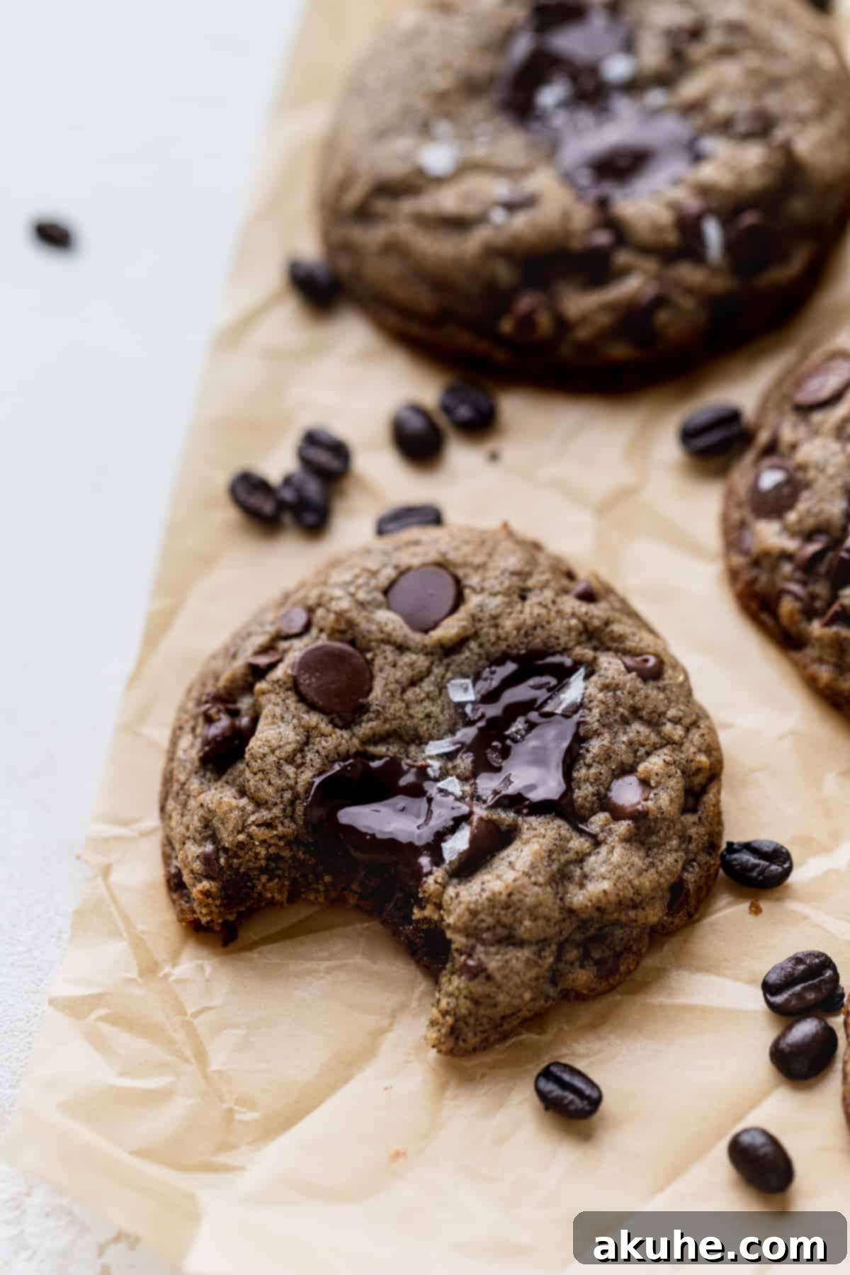 A delicious espresso chocolate chip cookie with a bite taken out, showing its soft interior.
