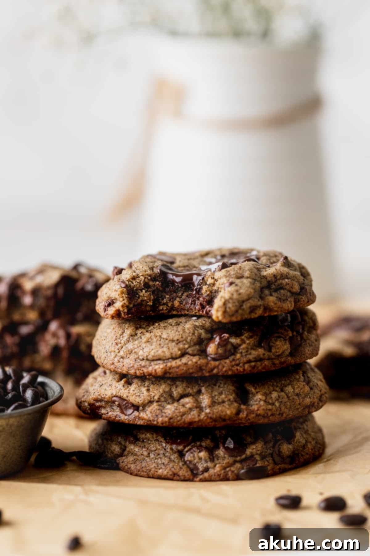 A stack of golden espresso chocolate chip cookies, one with a missing bite, tempting the viewer.