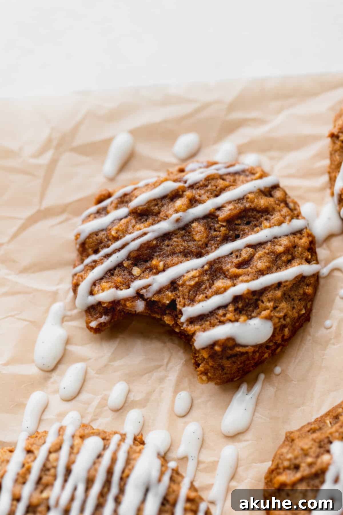 A perfectly baked pumpkin oatmeal cookie with a bite taken out, revealing its soft and chewy texture.