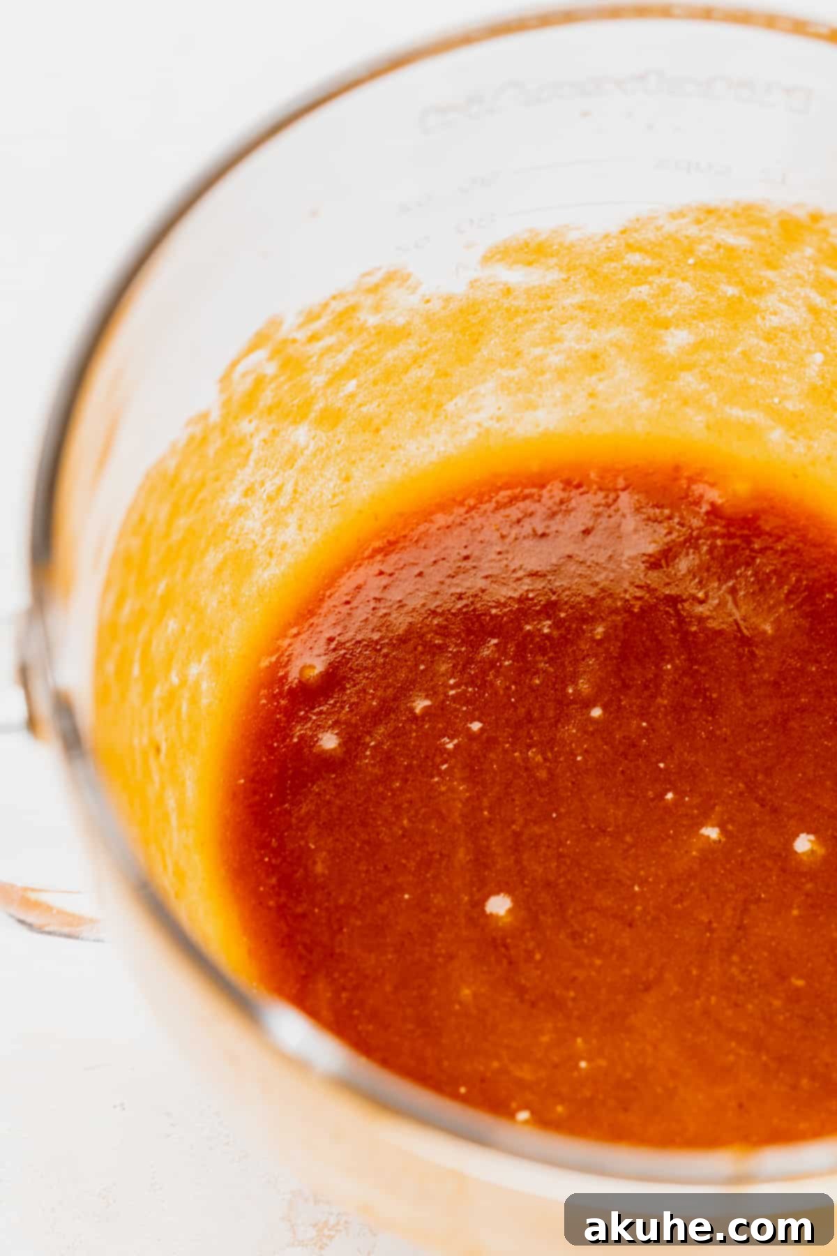 Cookie dough batter being mixed in a glass bowl.