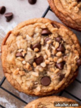 A beautiful stack of brown butter toffee chocolate chip cookies on a wire rack.