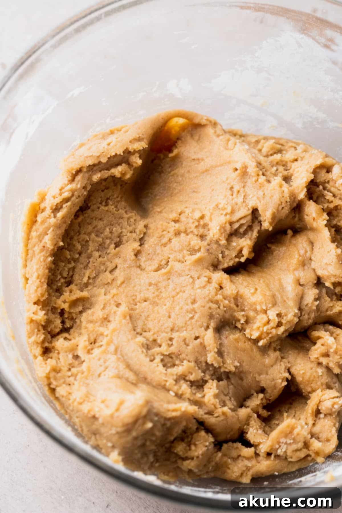 Rich chocolate chip and toffee cookie dough in a glass bowl, showcasing its readiness for baking.