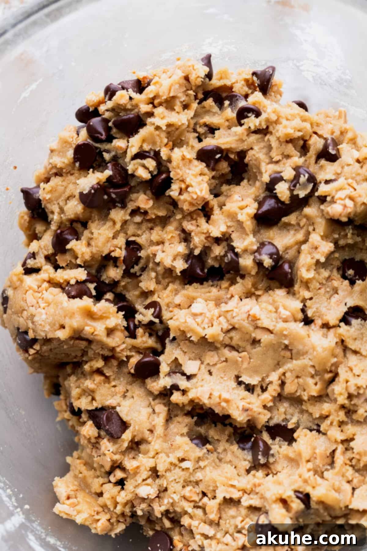 Another angle of the delectable cookie dough in a glass bowl, highlighting its inviting texture.