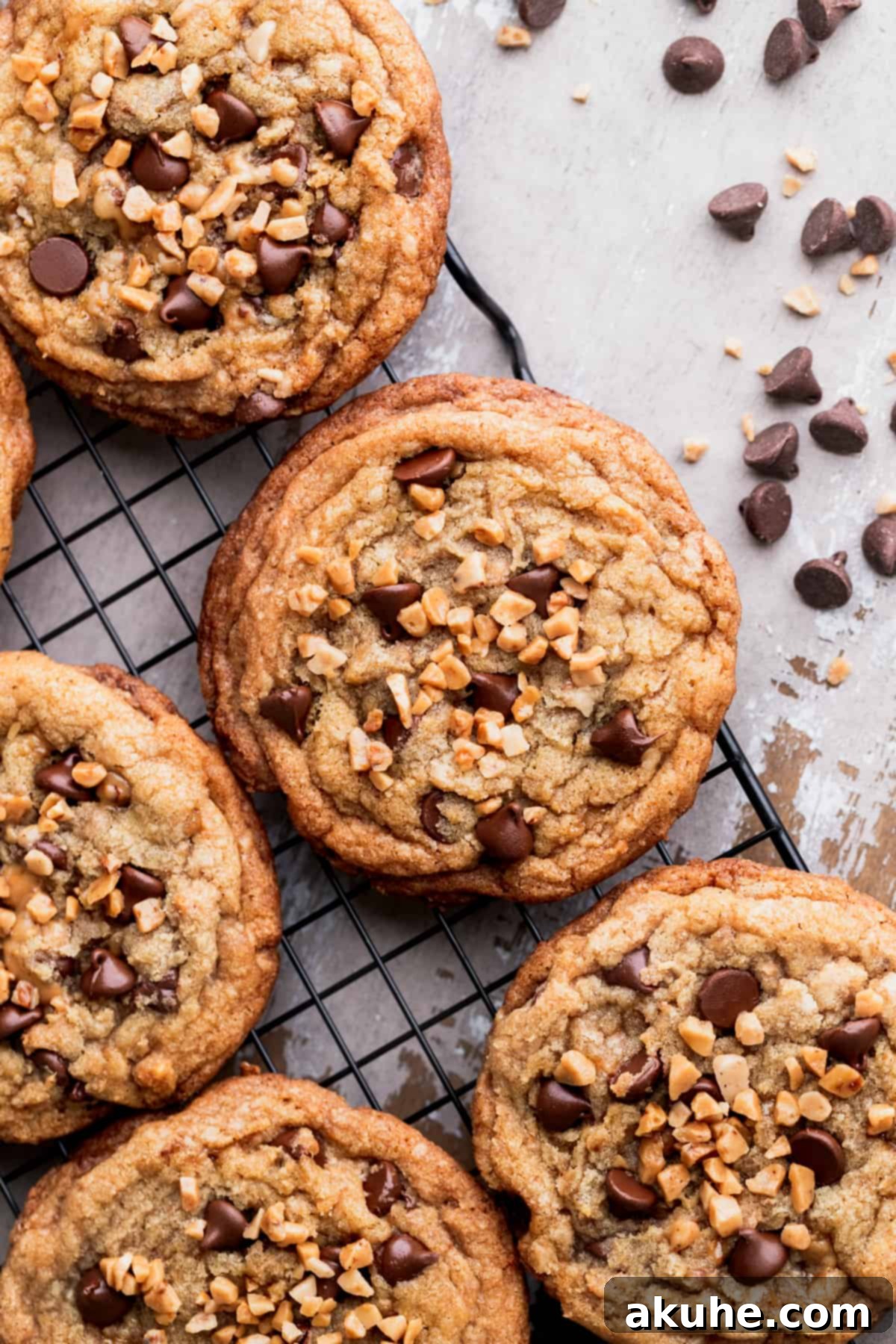 A close-up view of a baked brown butter toffee cookie, highlighting its texture and visible chocolate and toffee pieces.