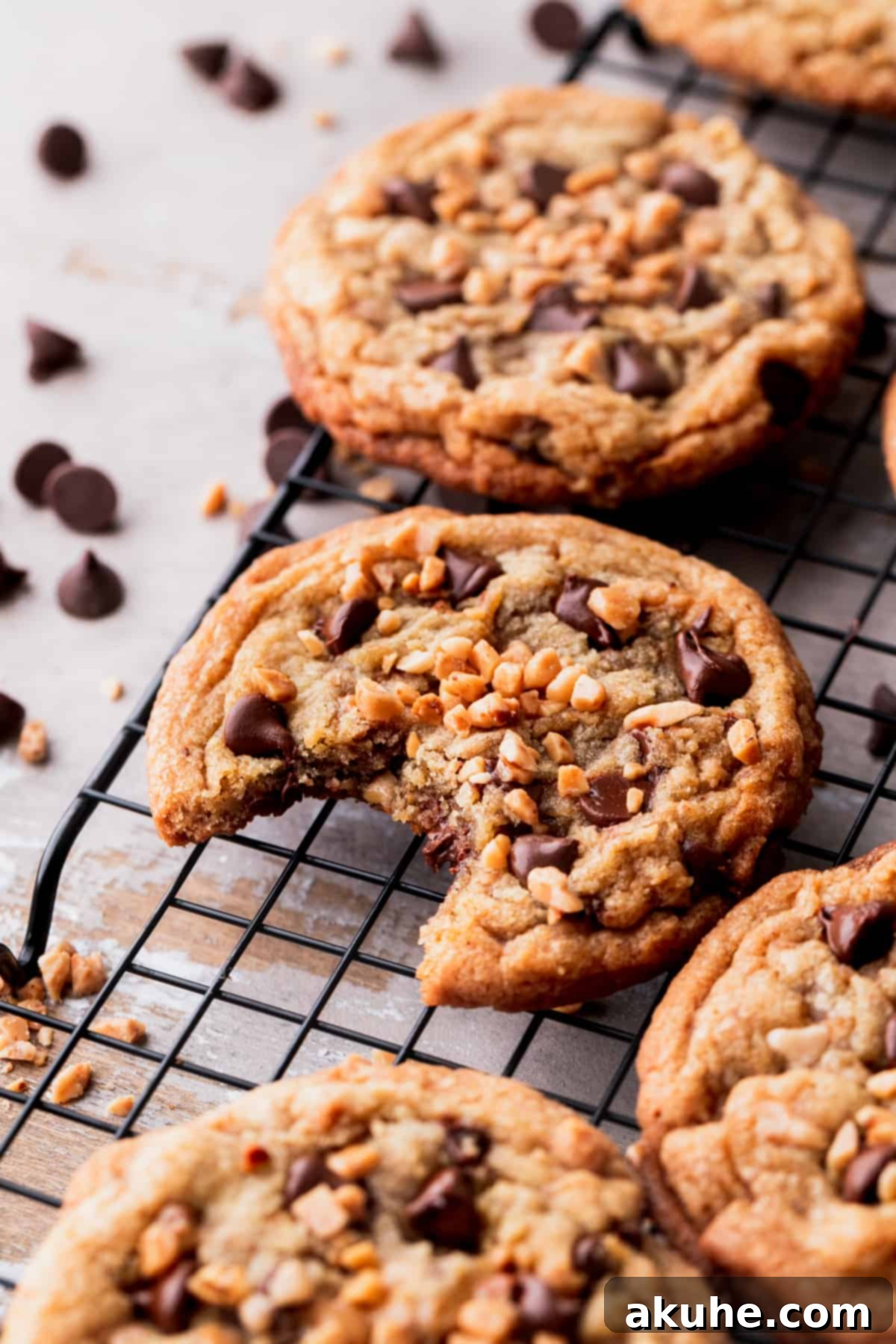 A delicious brown butter toffee cookie with a bite taken out, revealing its soft, chewy interior.