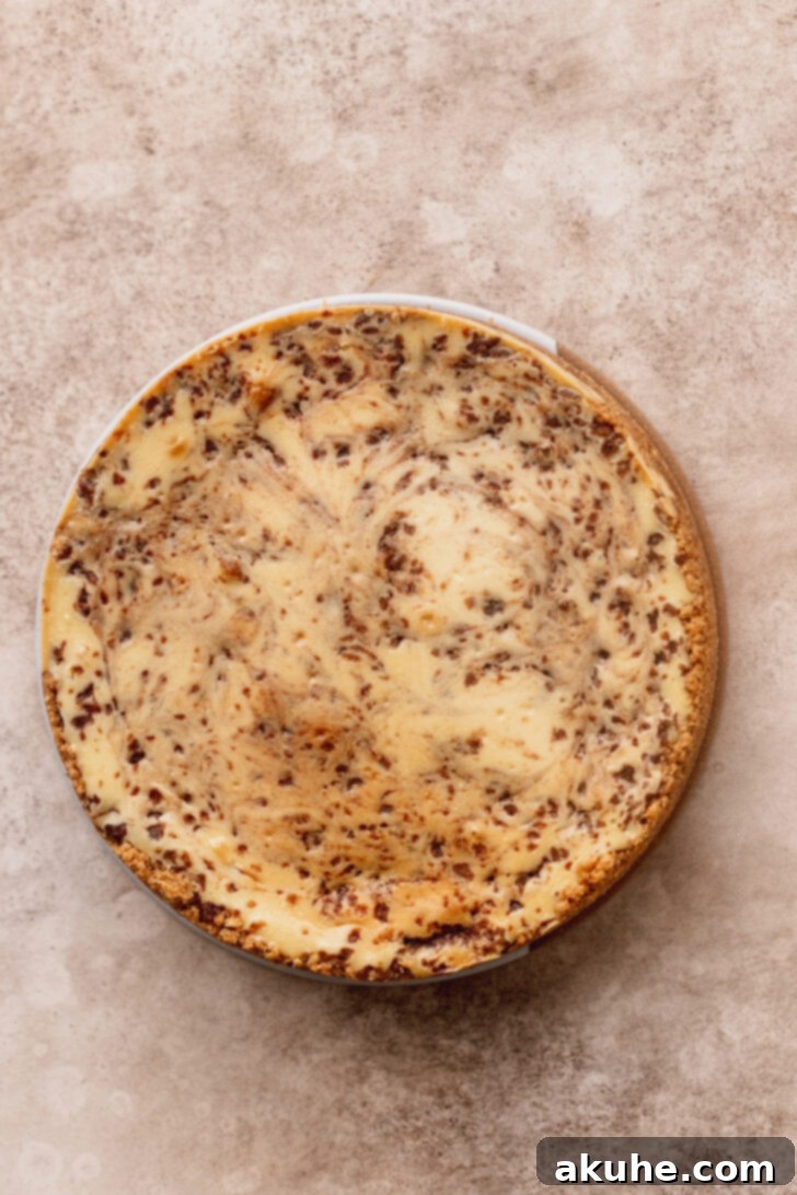 Cinnamon Swirl Cheesecake 8 A freshly baked cheesecake, cooled and ready for chilling, presented on a decorative platter.
