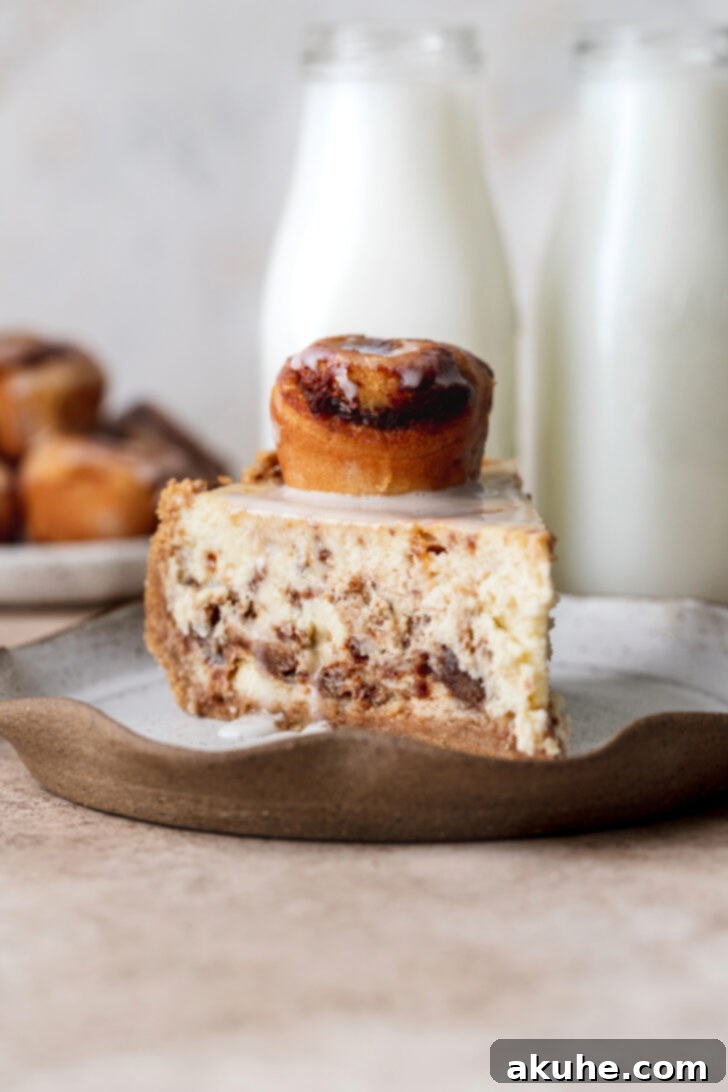 Cinnamon Swirl Cheesecake 10 A single slice of Cinnamon Roll Cheesecake presented on a plate, ready to be enjoyed.