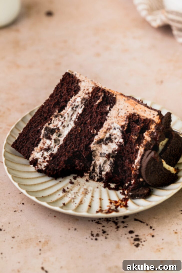 Decadent Oreo Dream Cake 11 Close-up of a delightful slice of Oreo cake on a white plate, with a bite taken