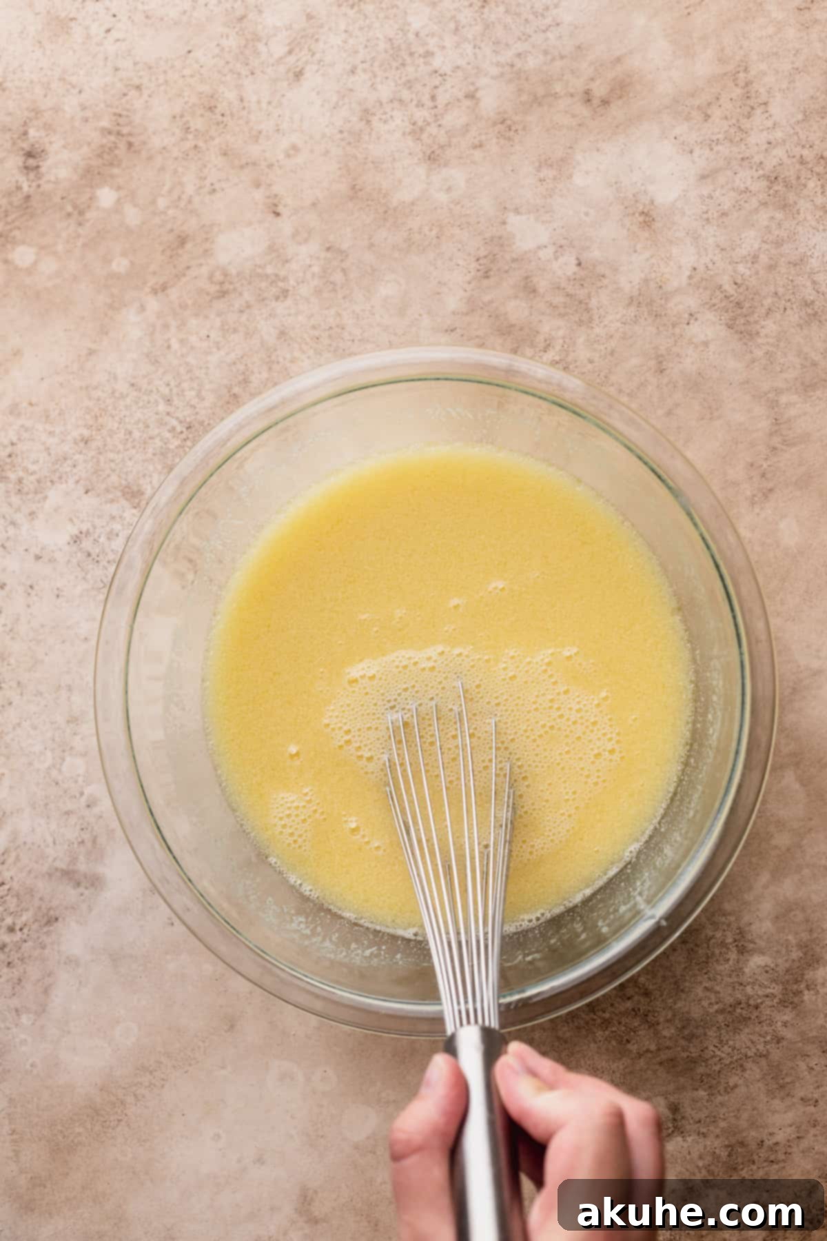 Wet ingredients beautifully mixed in a clear glass bowl, ready for combining.