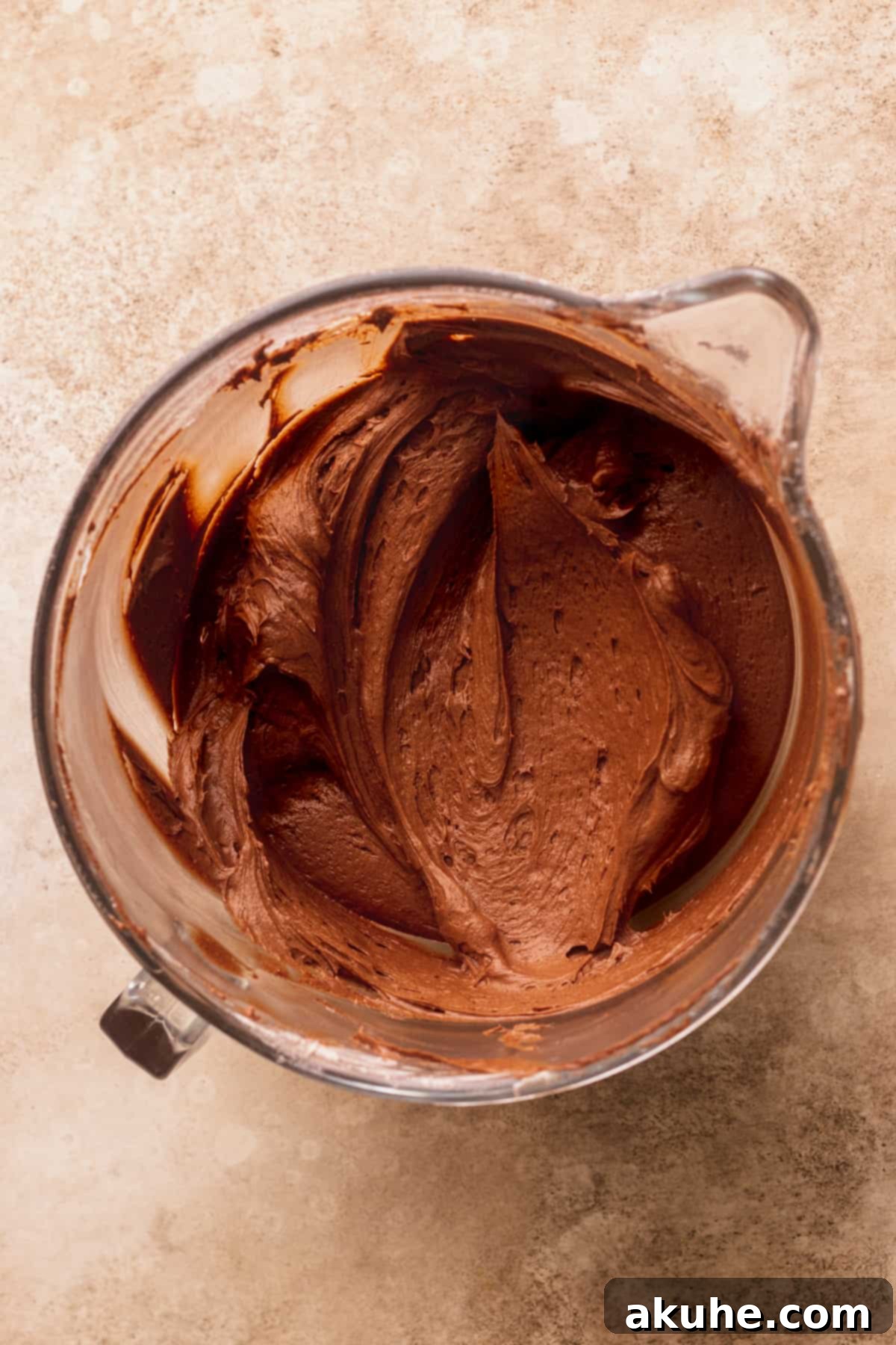 Smooth, rich chocolate cream cheese frosting prepared in a glass bowl.