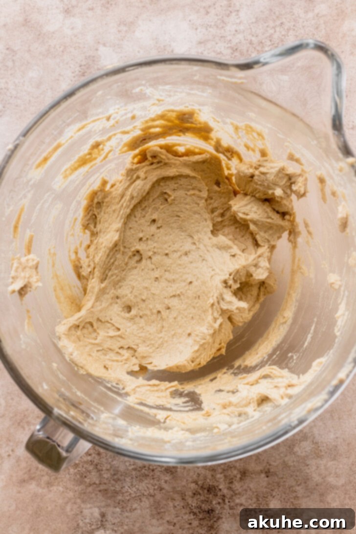 Churro Cookie Delights 4 Wet ingredients (butter, sugar, eggs, vanilla) being mixed in a bowl.