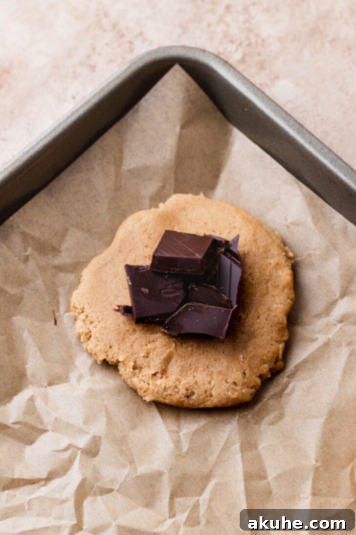 Churro Cookie Delights 6 Cookie dough ball with a hole created and being filled with chopped chocolate.