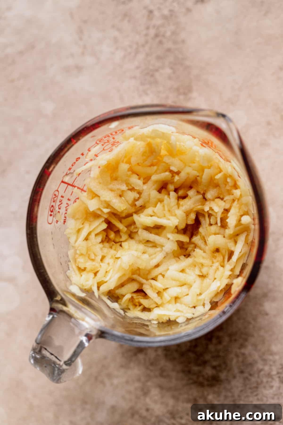 Irresistible Apple Toffee Cake 6 Freshly shredded apples, squeezed of excess juice, in a jar.