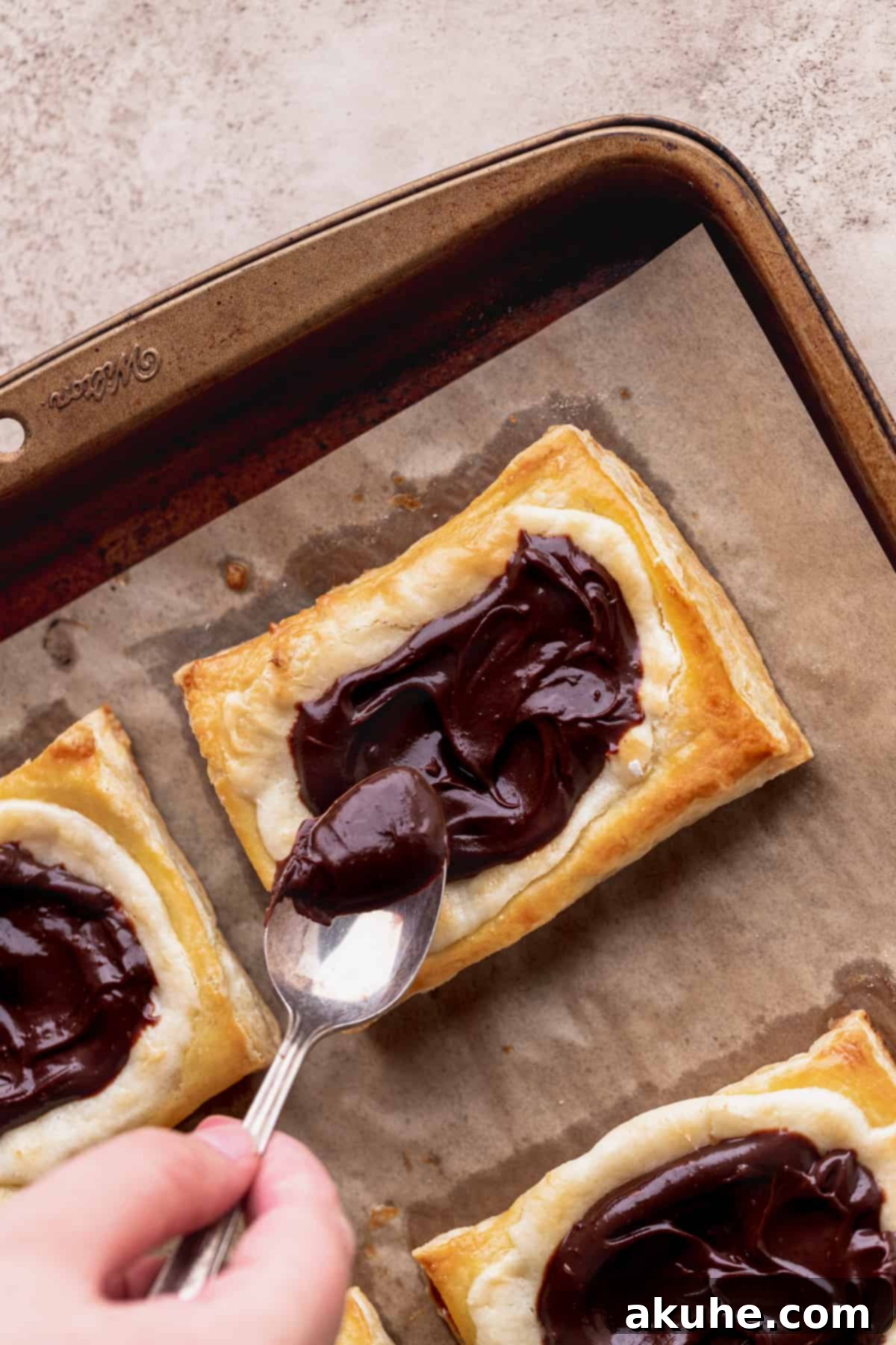 Indulgent Chocolate Cream Cheese Danish 8 Spreading chocolate on top of pastry.