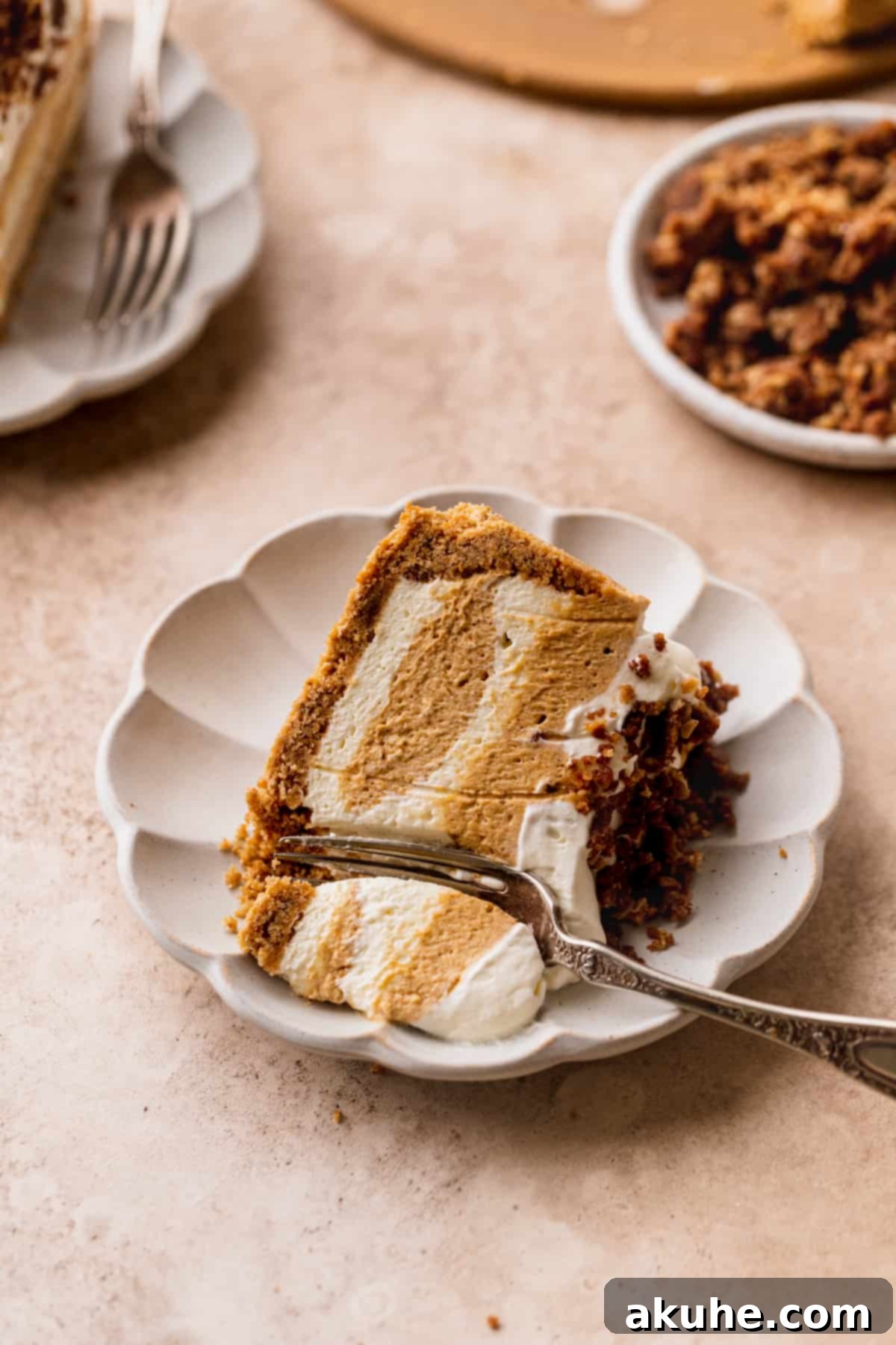 Marbled No Bake Pumpkin Cheesecake 16 Swirled no bake pumpkin cheesecake on its side with a fork inserted.
