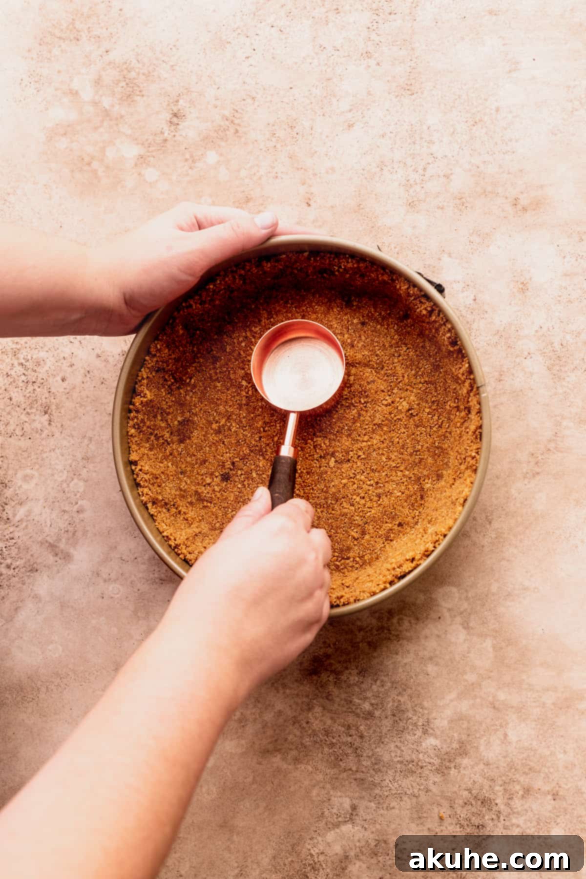 Marbled No Bake Pumpkin Cheesecake 5 Pressing down the crust in a springform pan.