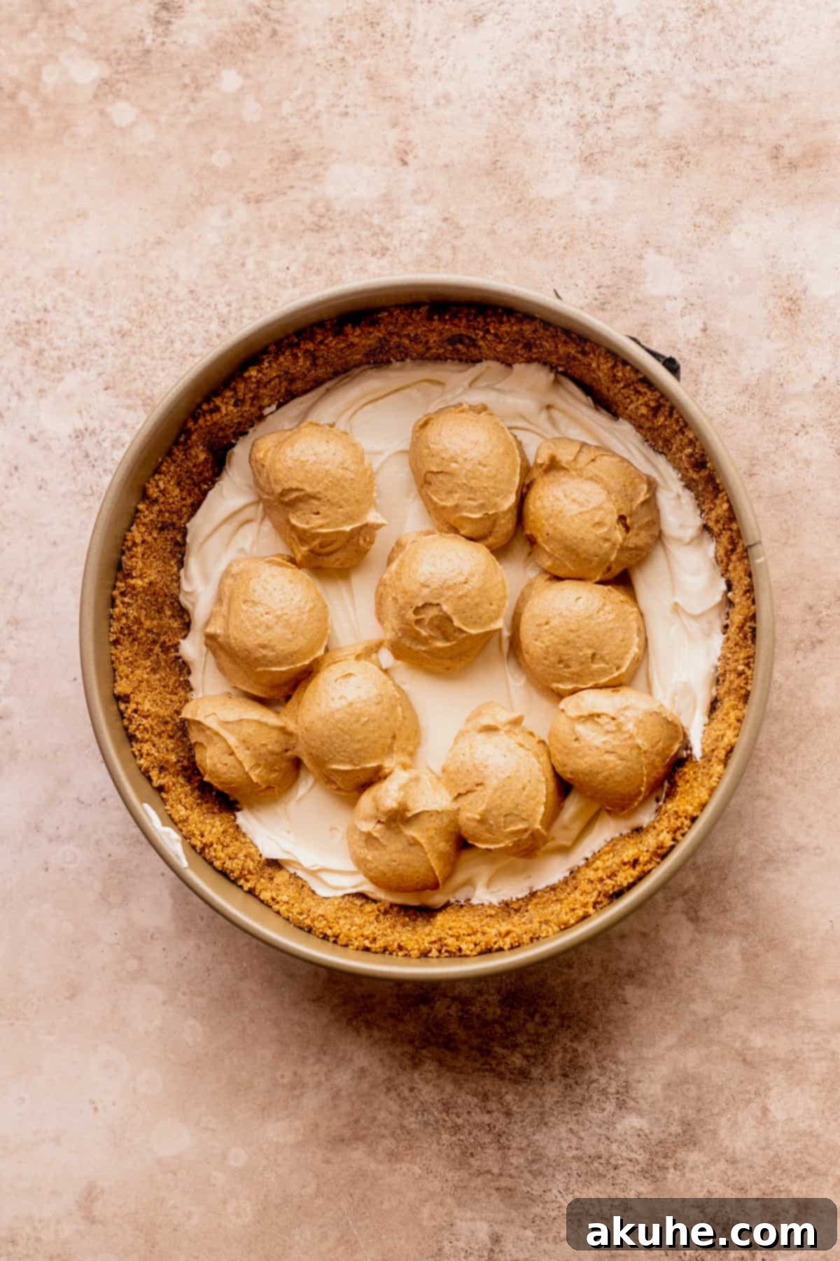 Marbled No Bake Pumpkin Cheesecake 10 Scoops of pumpkin batter on top of cheesecake.