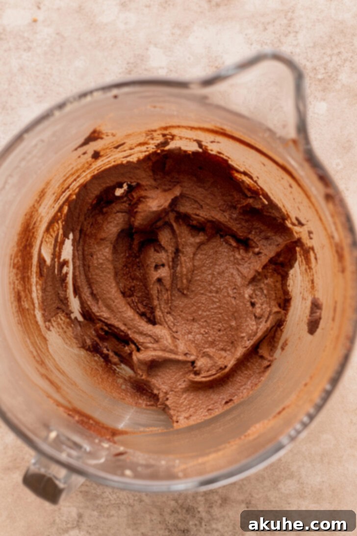 Decadent Oreo Brownie Cookies 4 Close-up of butter and sugars being creamed in a stand mixer, creating a light and fluffy mixture before adding chocolate.