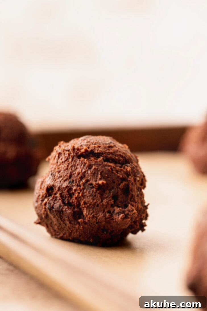 Decadent Oreo Brownie Cookies 7 Scooped cookie dough balls evenly spaced on a parchment-lined baking sheet, prepared for the oven.