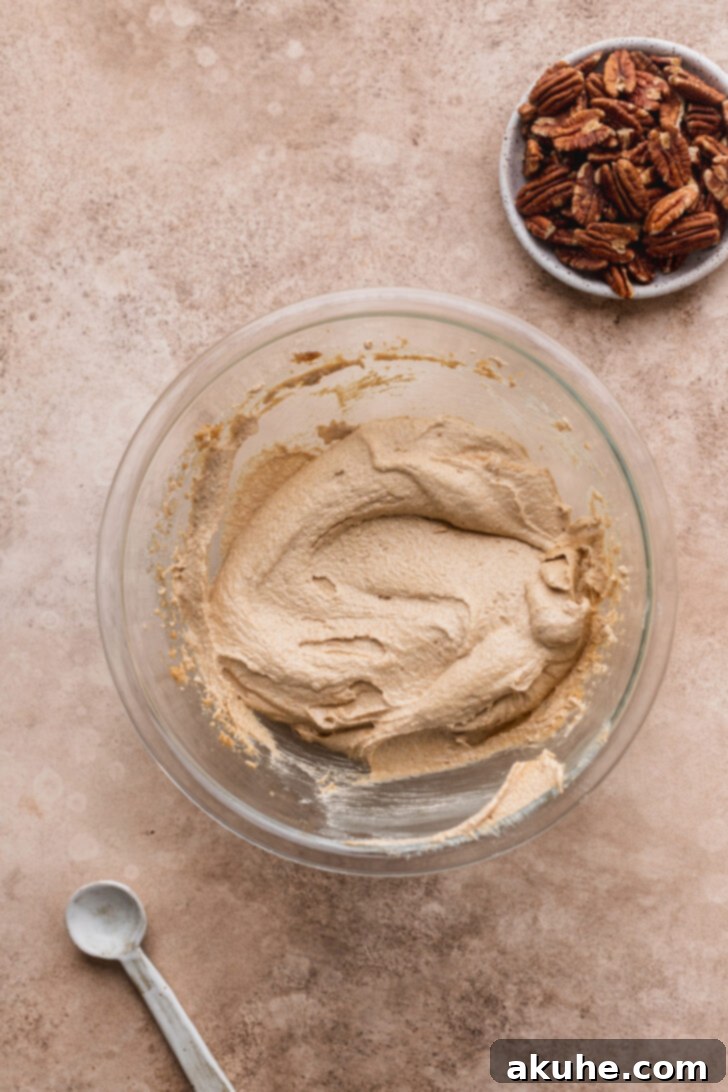 Toasted Pecan Chocolate Chip Delights 5 Wet ingredients, including butter and sugars, being creamed together in a mixing bowl until light and fluffy.