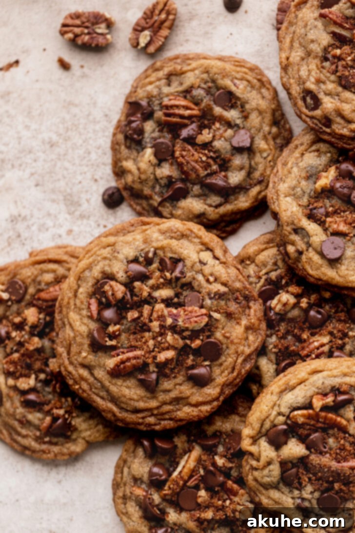 Toasted Pecan Chocolate Chip Delights 10 Top view of multiple cinnamon pecan chocolate chip cookies, stacked and arranged invitingly.