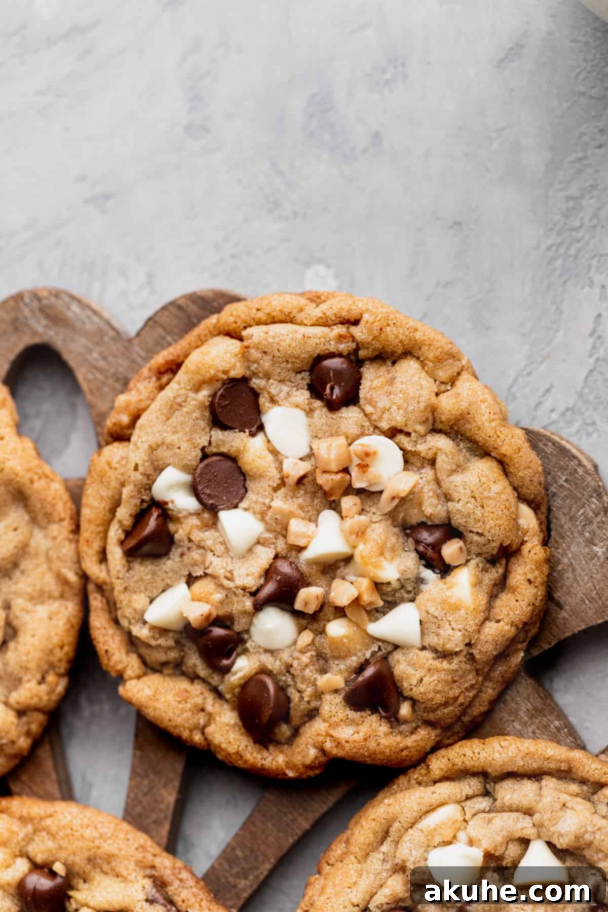 Decadent White Chocolate Toffee Cookies 3 Close-up view of two white chocolate toffee cookies, highlighting the melted chocolate and toffee pieces on top.