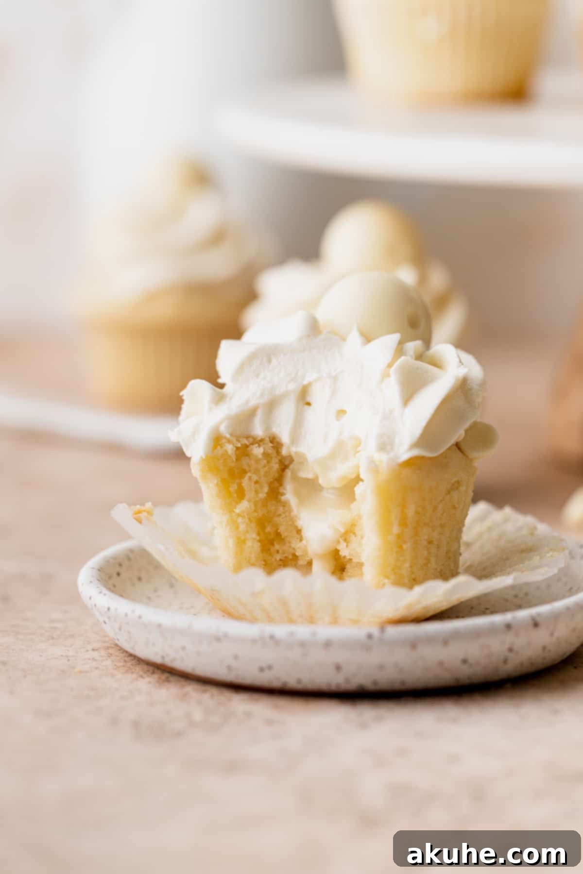 Decadent White Chocolate Cupcakes 11 A single, perfectly frosted white chocolate truffle cupcake resting on a white plate, invitingly presented.