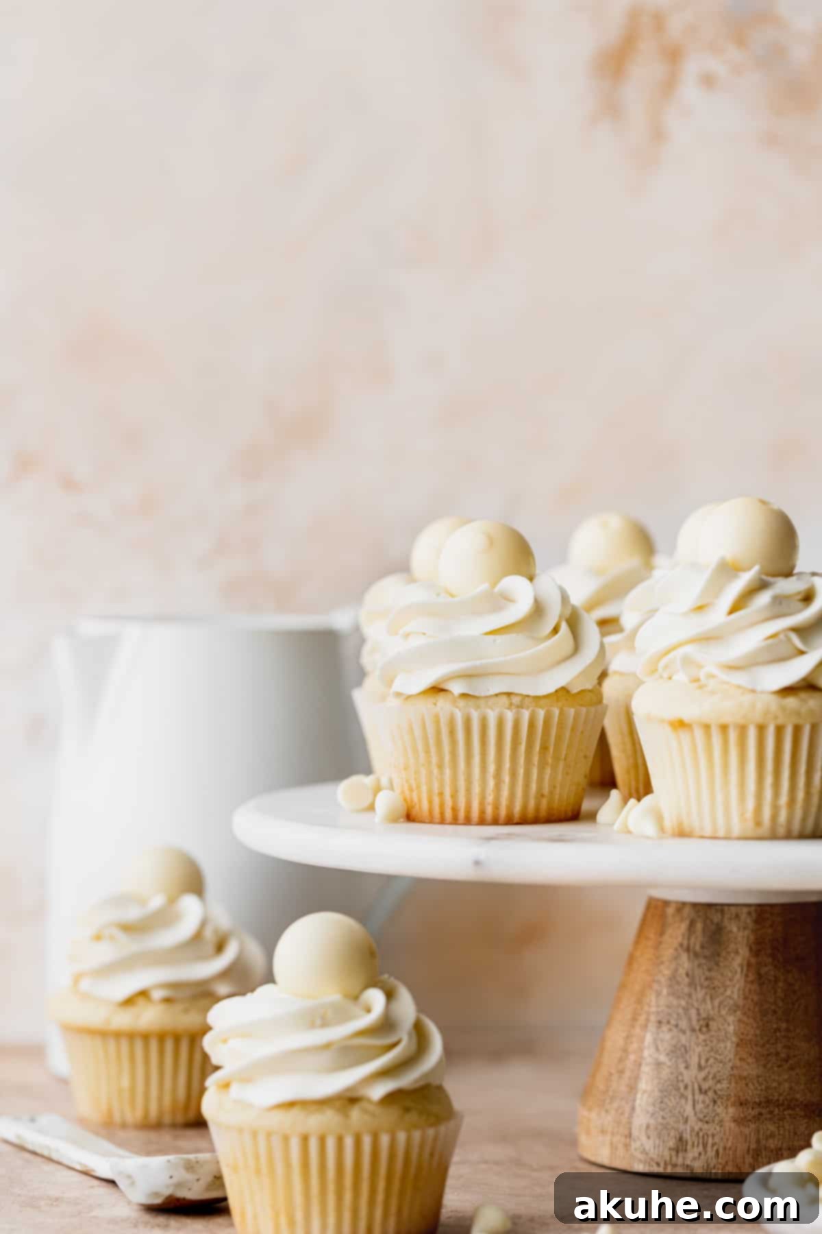 Decadent White Chocolate Cupcakes 3 A stunning display of white chocolate truffle cupcakes artfully arranged on a multi-tiered cake stand, ready to be enjoyed.