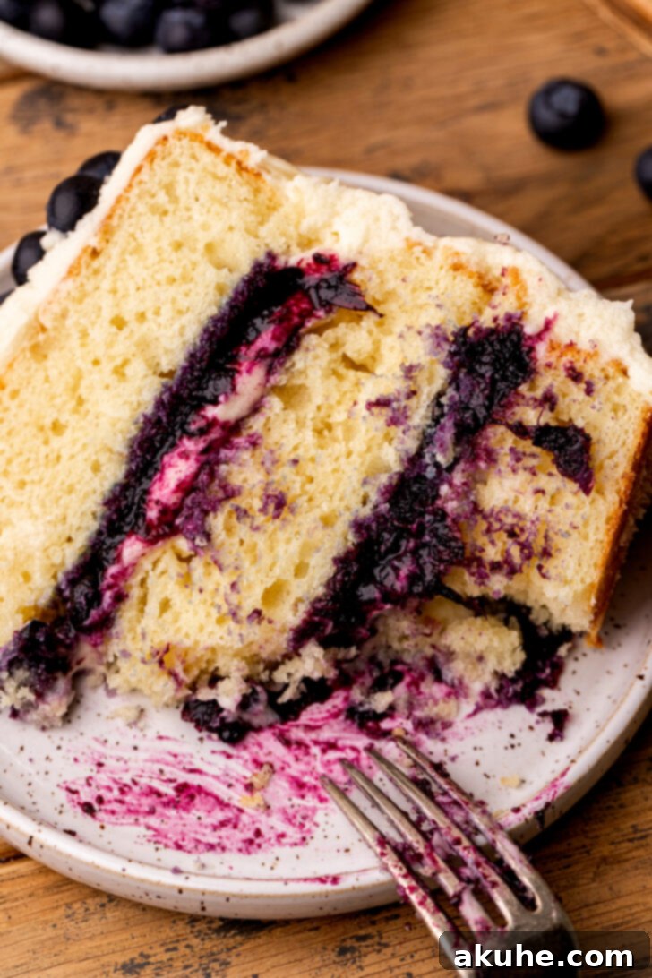 Blueberry Bliss Cake 13 A slice of blueberry jam cake on a plate with a bite taken out, highlighting its deliciousness.
